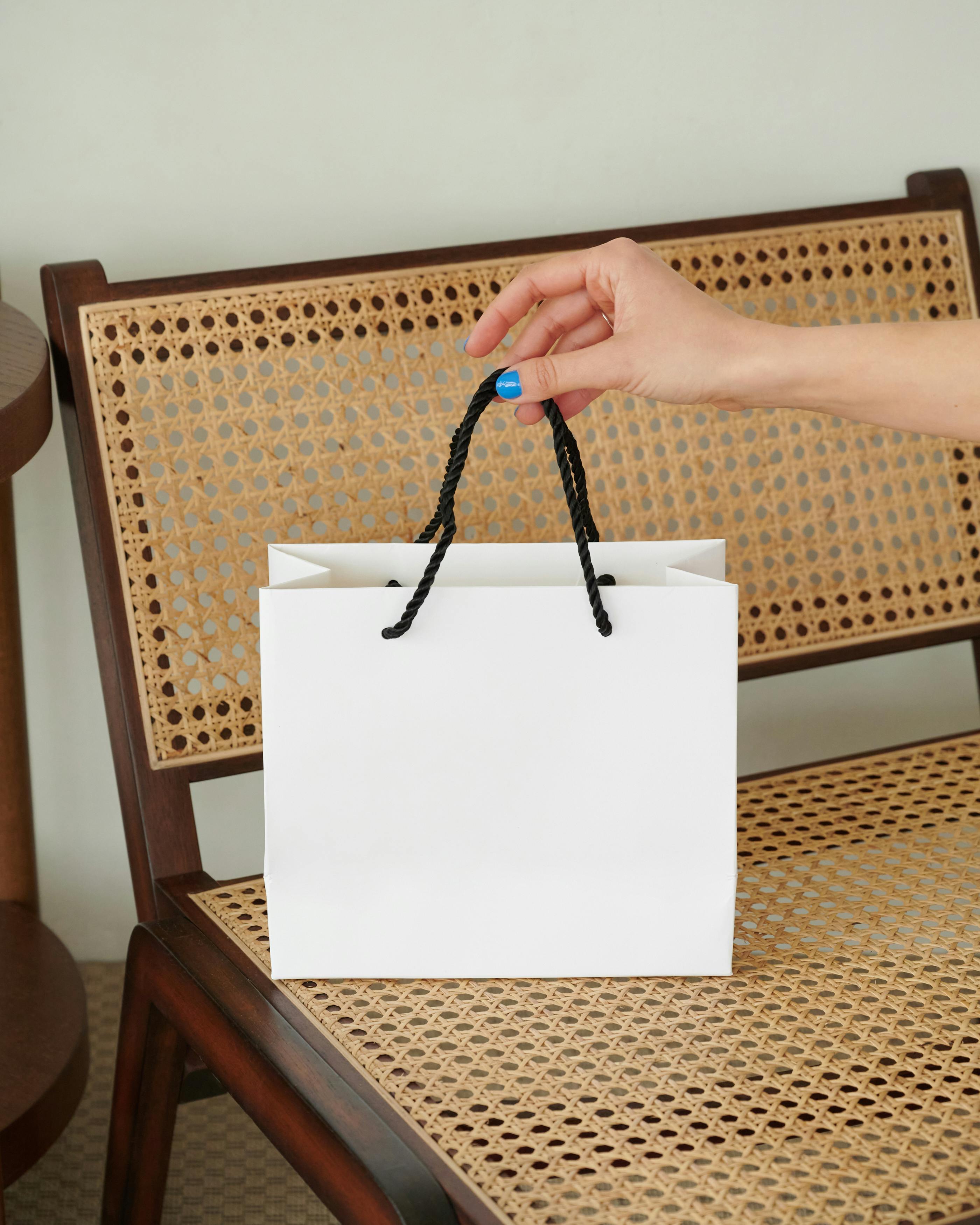 Eine Person hält eine weiße Geschenktüte | Quelle: Pexels
