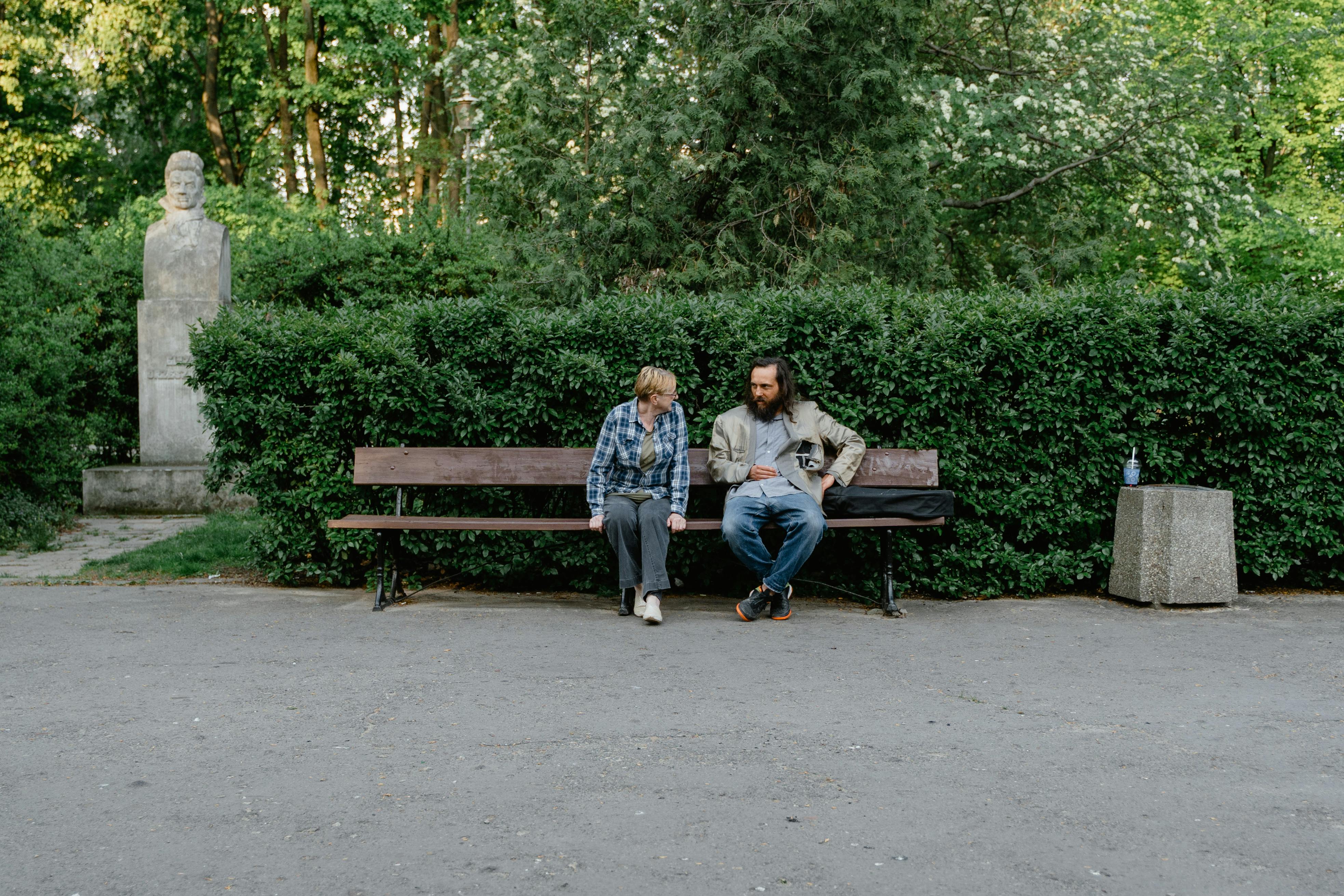 Eine Frau im Gespräch mit einem mittellosen Mann in einem Park | Quelle: Pexels