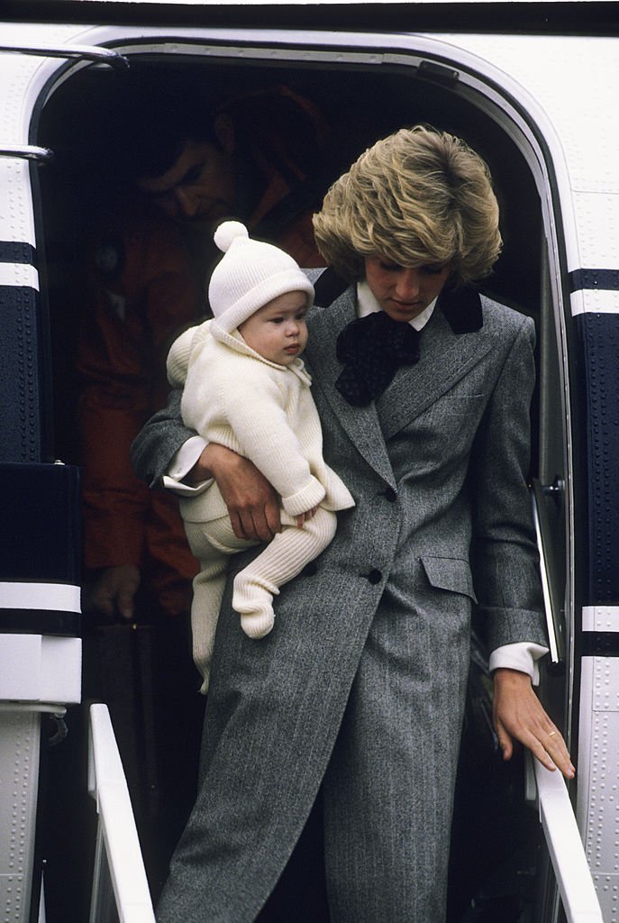 Diana, Prinzessin von Wales, trägt ihren Sohn, Prinz Harry, auf dem Flughafen Aberdeen aus einem Flugzeug. | Quelle: Getty Images