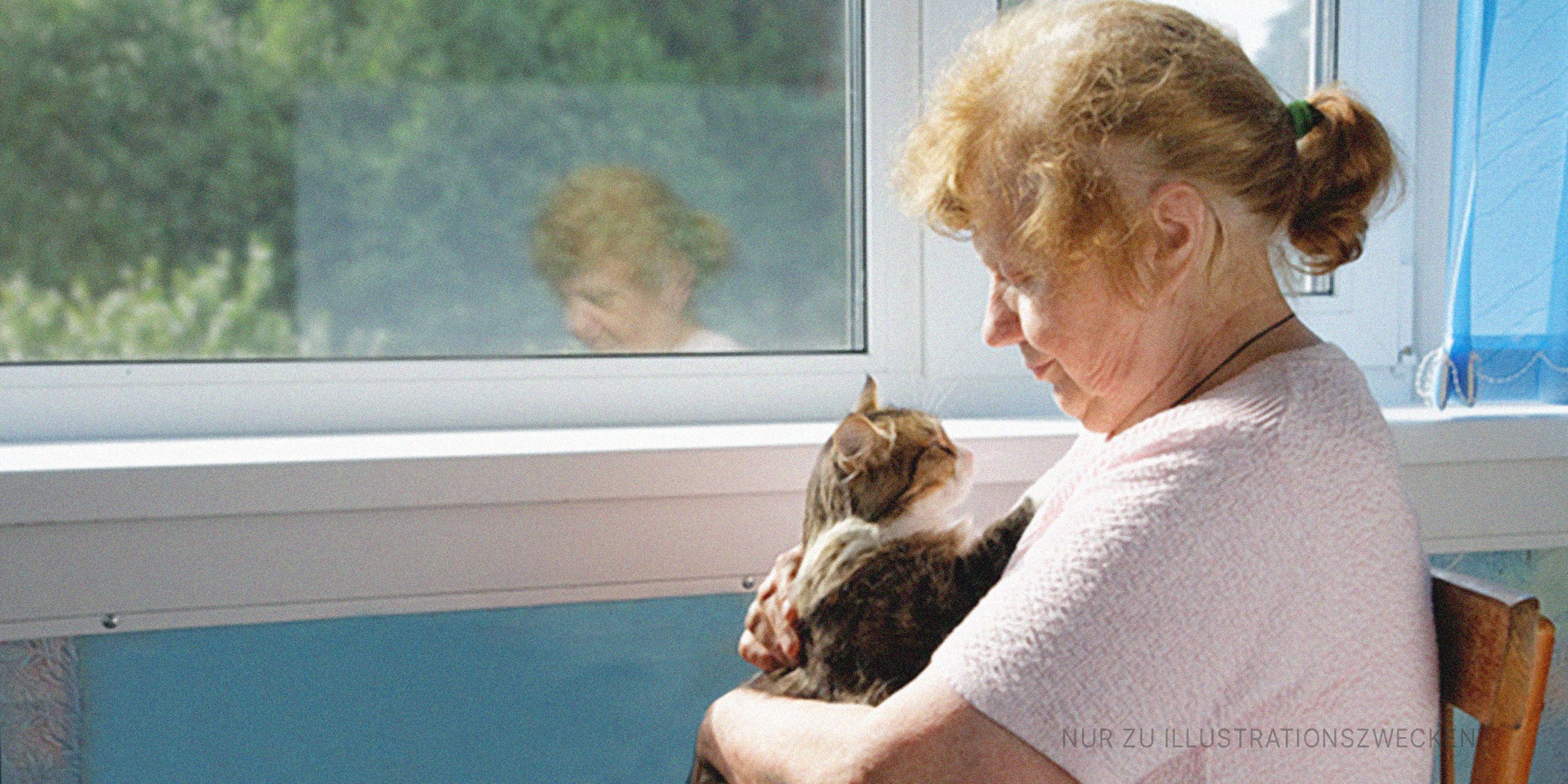 Eine alte Frau, die eine Katze hält. | Quelle: Shutterstock