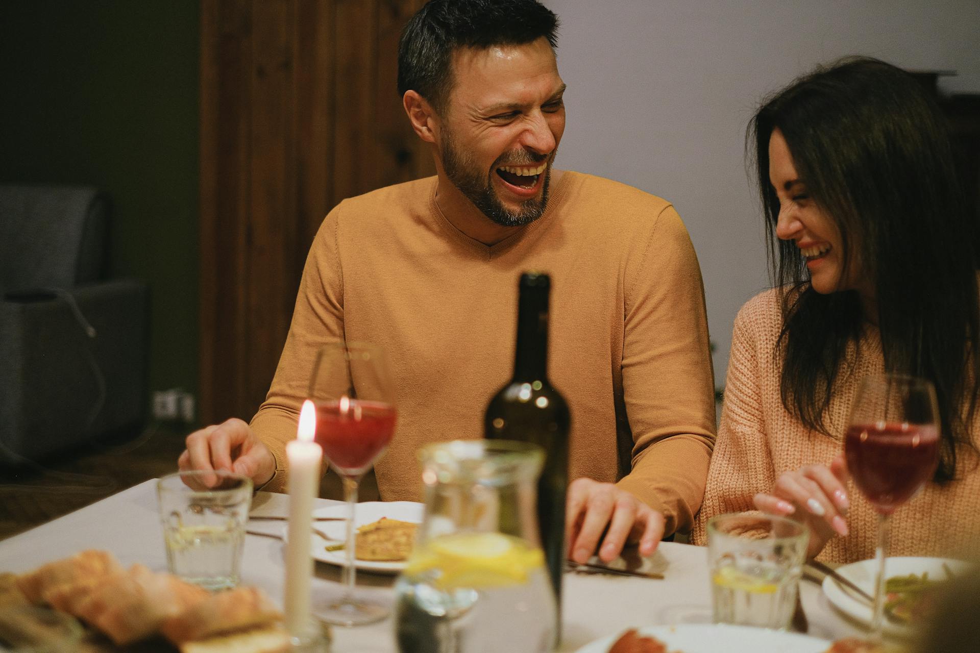 Zwei Menschen lachen beim Abendessen | Quelle: Pexels