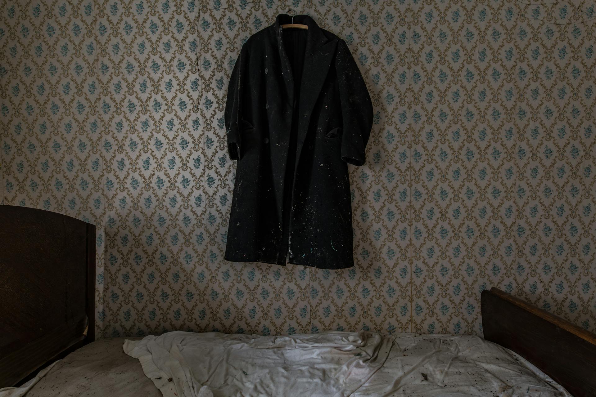 Eine alt aussehende Matratze in einem Zimmer, in dem eine Jacke an der Wand hängt | Quelle: Pexels