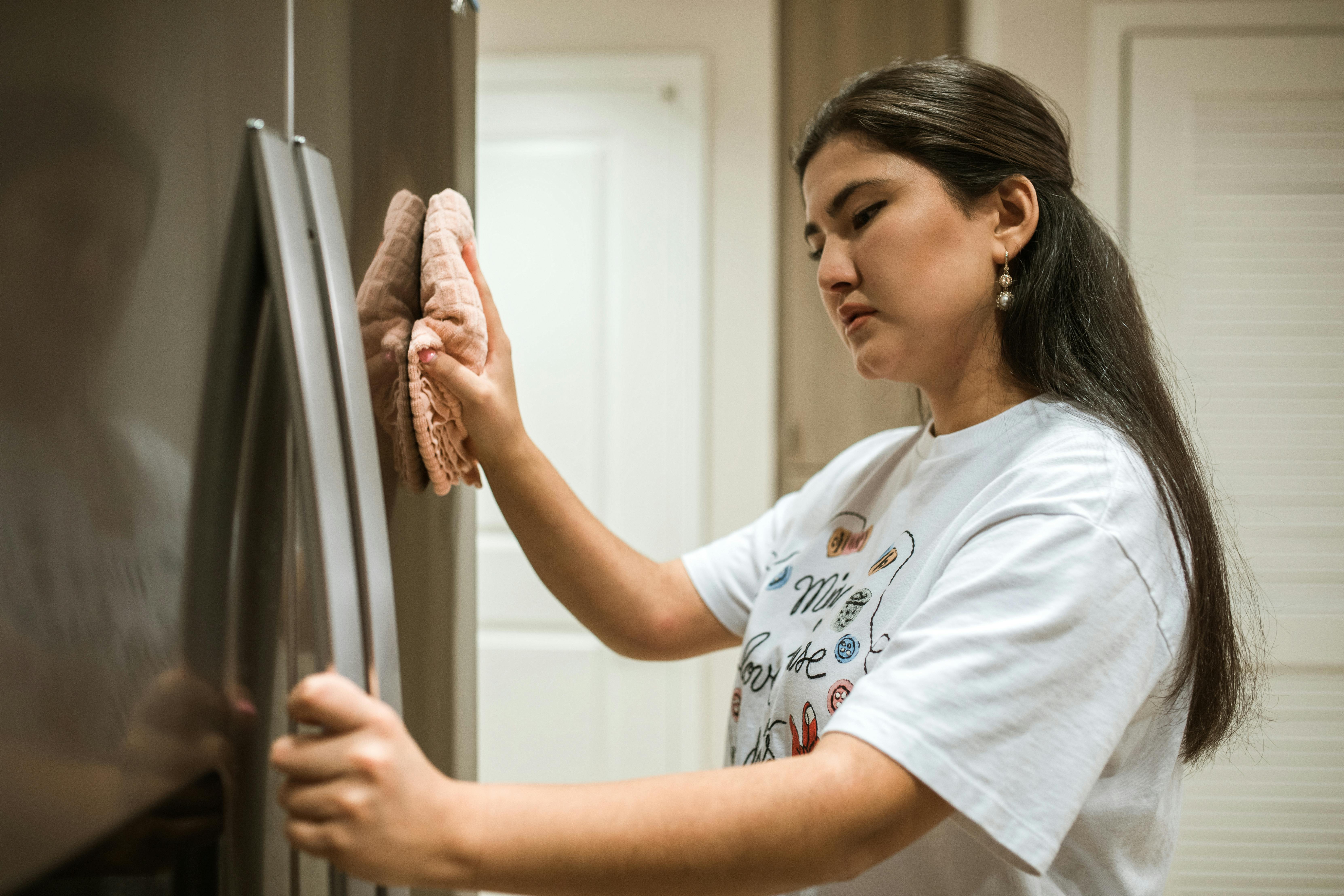 Eine Frau reinigt einen Kühlschrank. | Quelle: Pexels