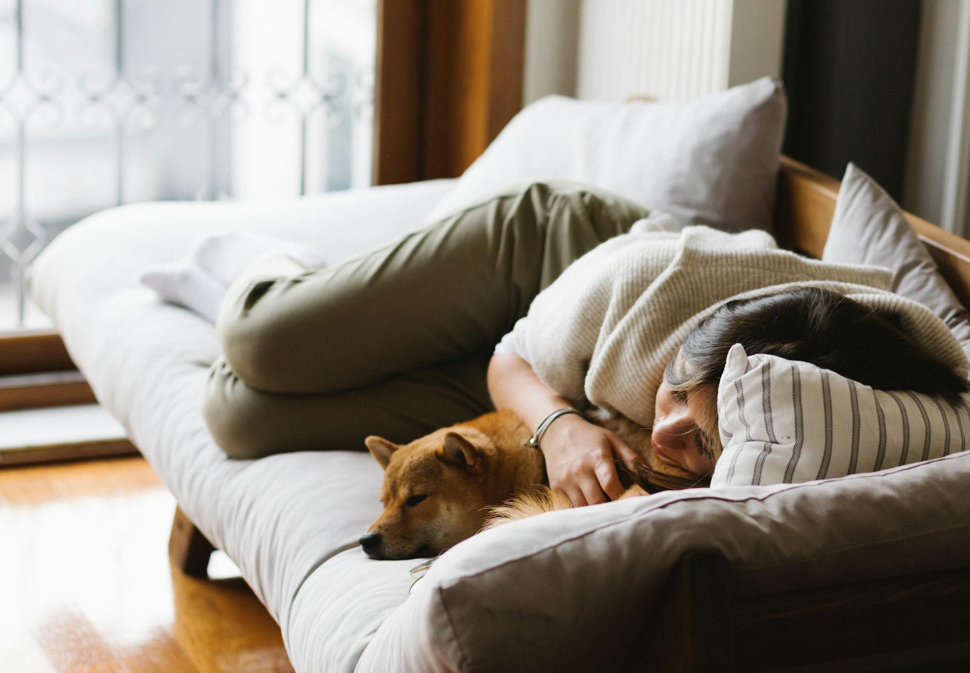 Eine Frau, die sich auf einem Sofa zusammengerollt hat | Quelle: Pexels