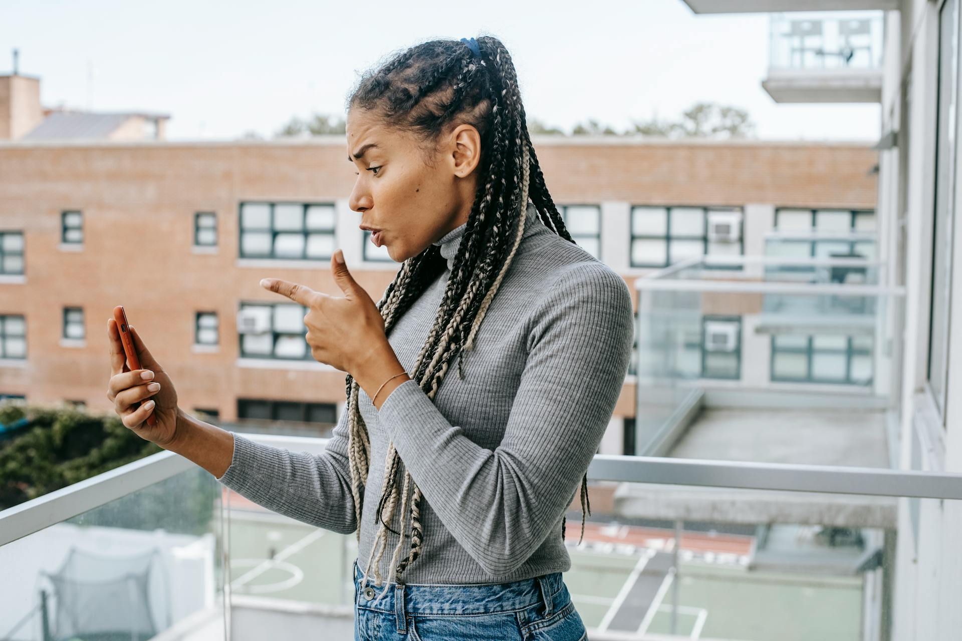 Eine wütende Frau macht Handgesten, während sie ein Videogespräch mit jemandem auf ihrem Telefon führt | Quelle: Pexels