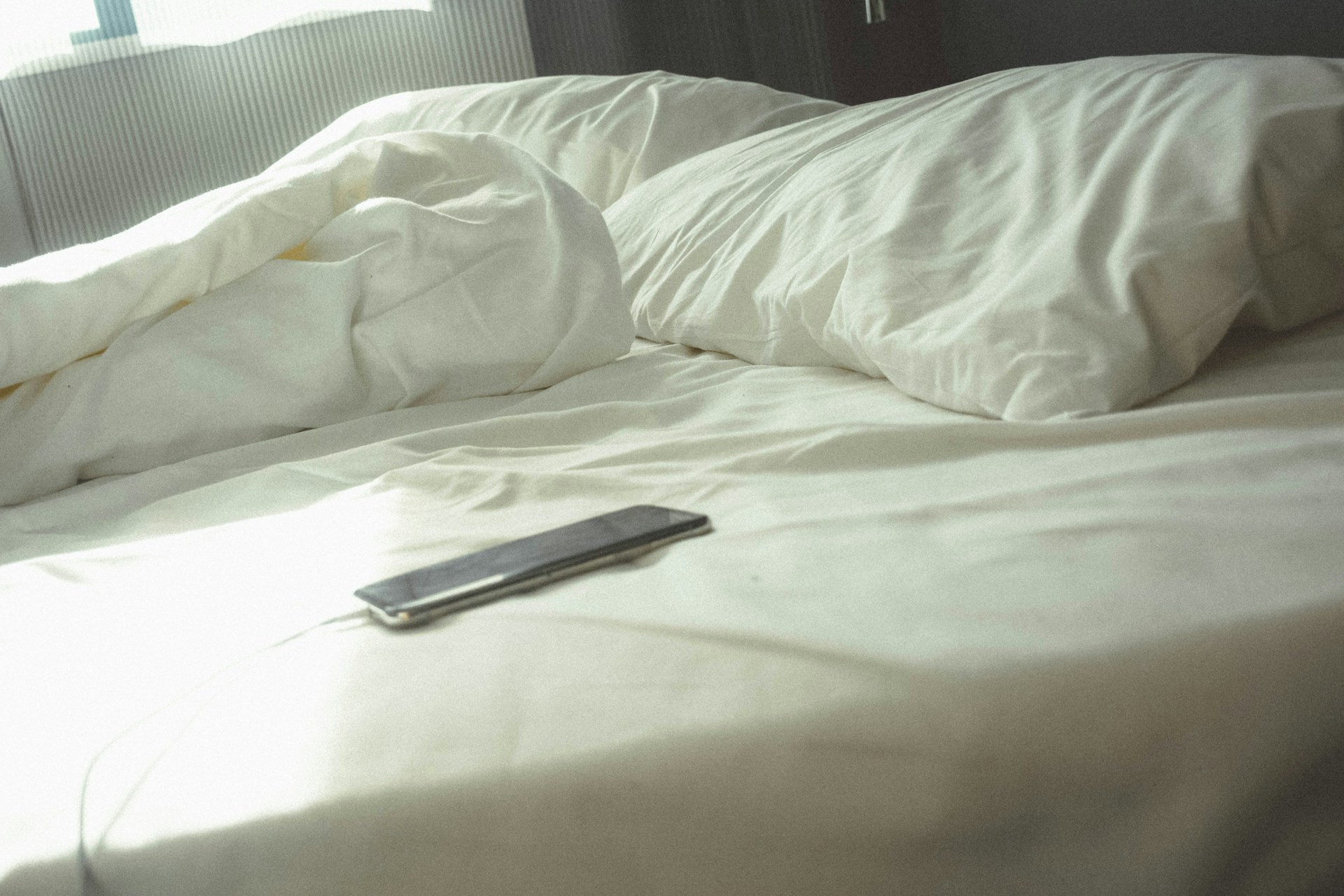 Ein Telefon auf dem Bett | Quelle: Unsplash