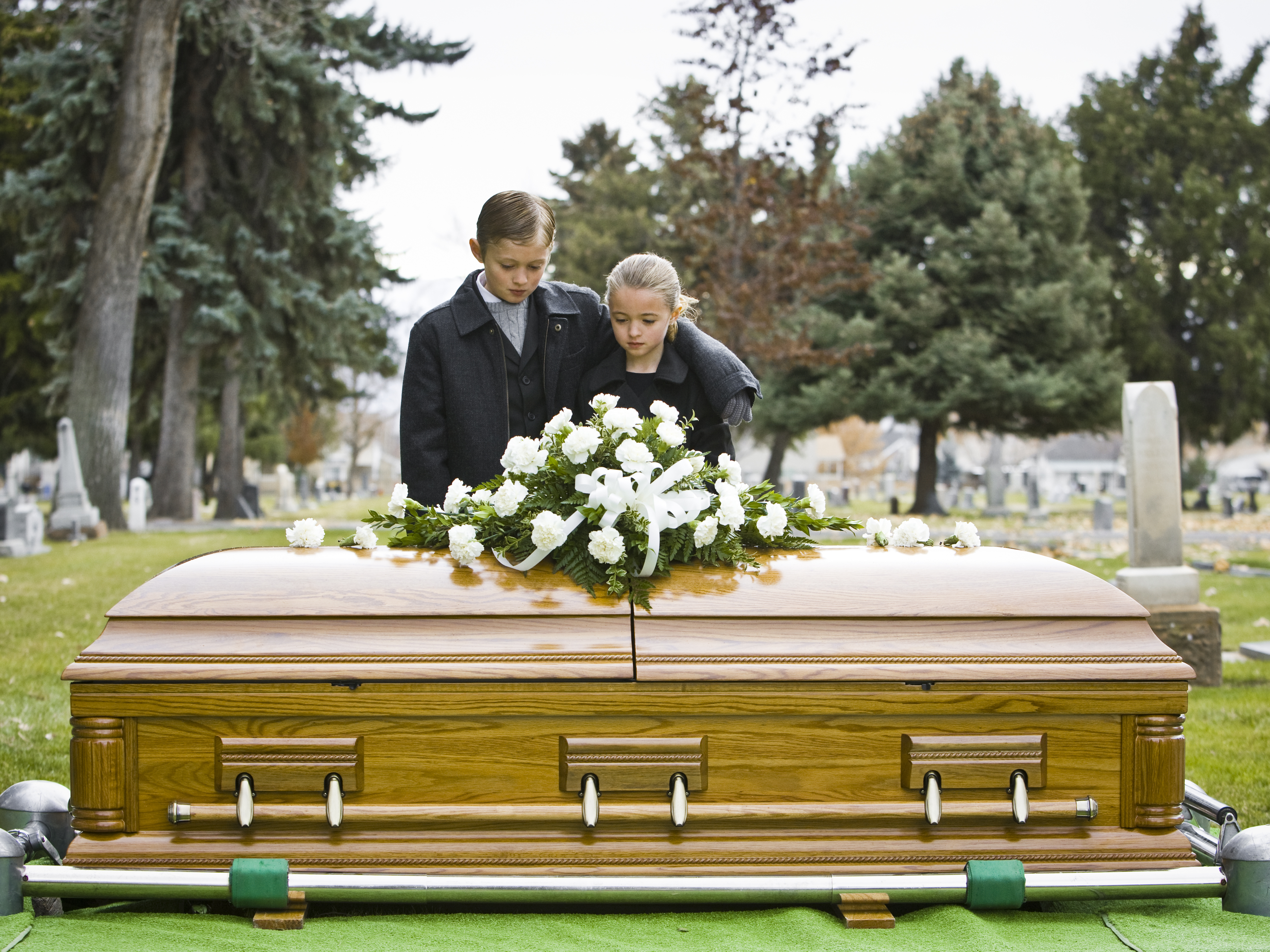 Ein Bruder und eine Schwester bei einer Beerdigung | Quelle: Getty Images