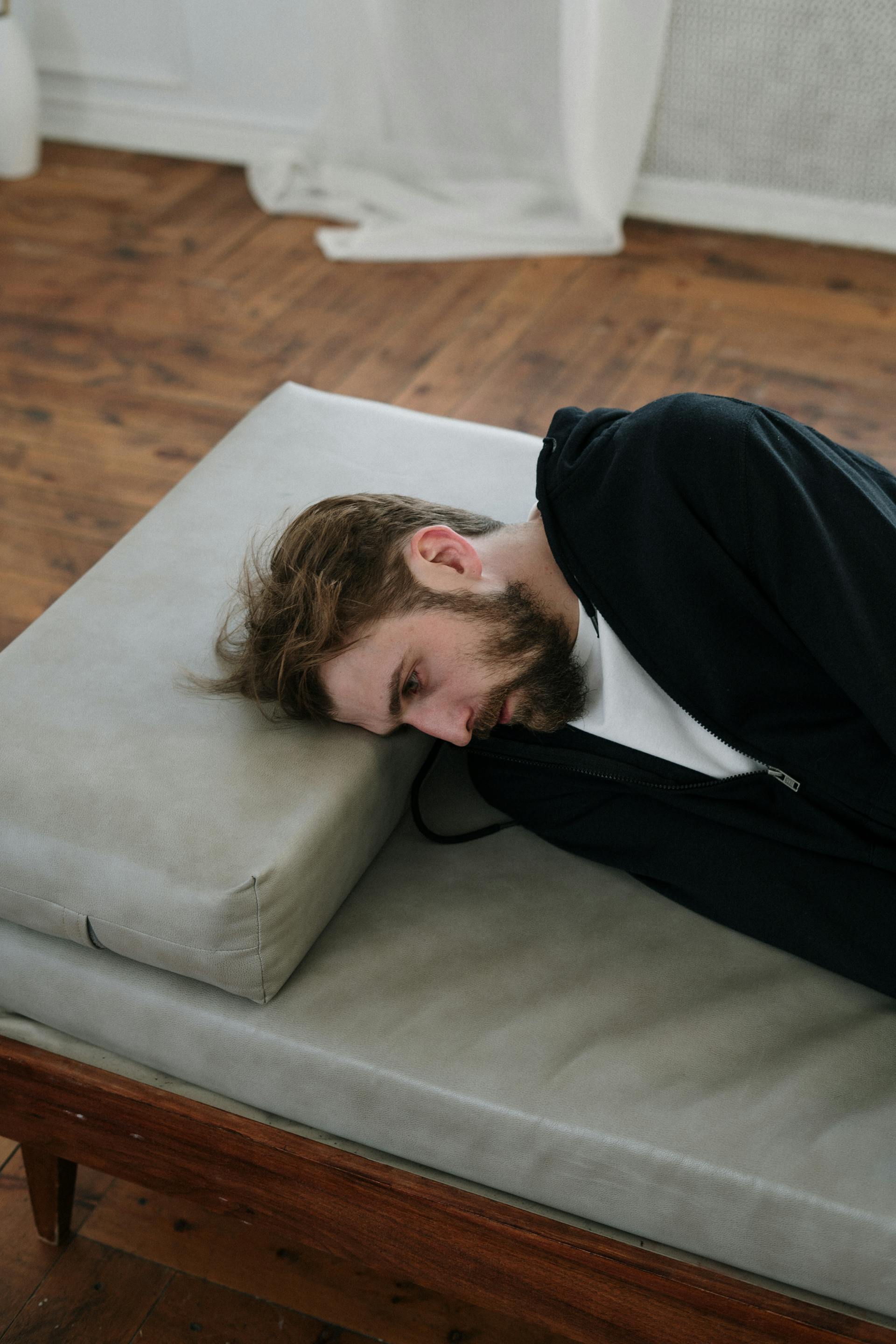 Ein Mann, der auf einem Sofa liegt | Quelle: Pexels