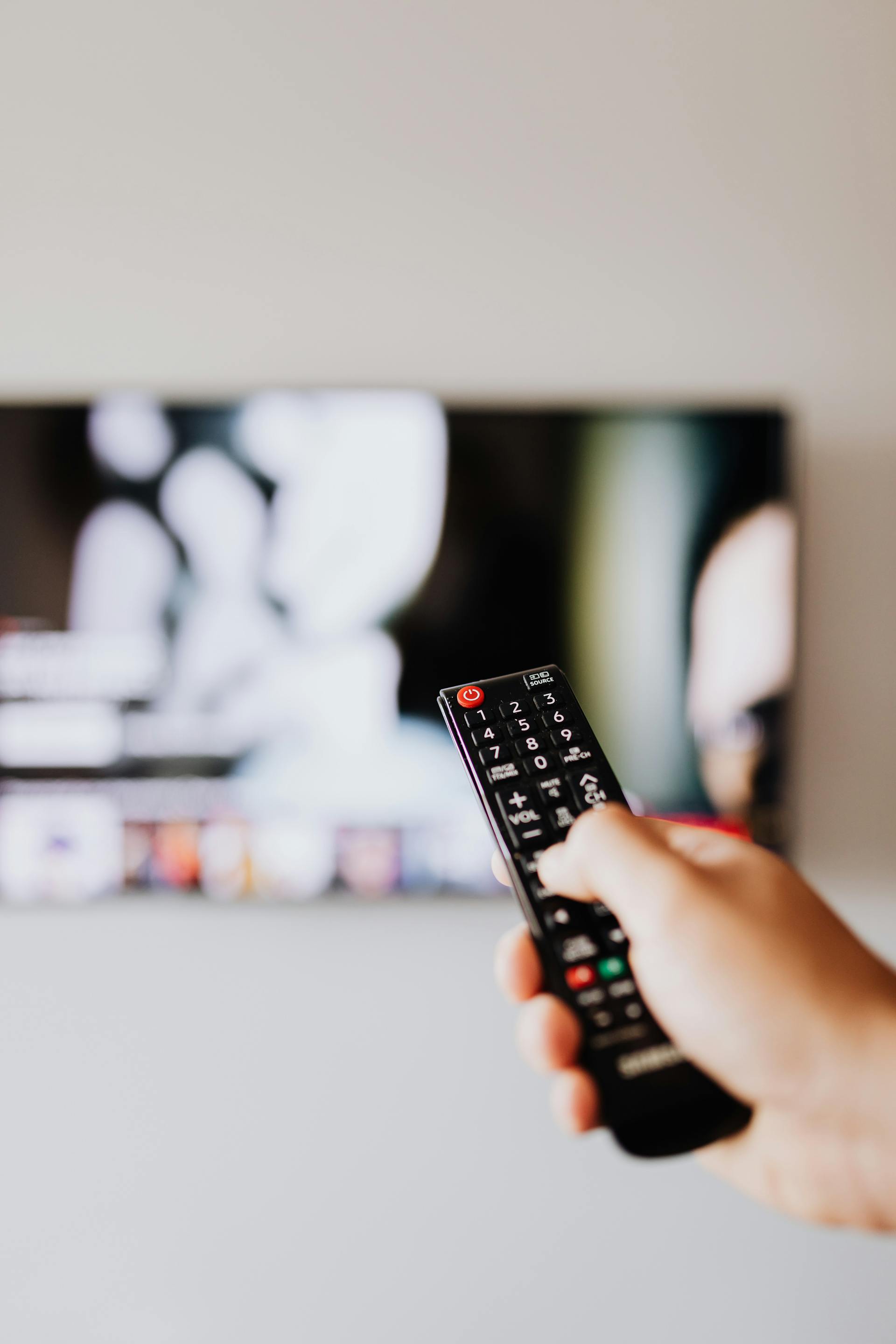 Eine Person hält eine TV-Fernbedienung | Quelle: Pexels