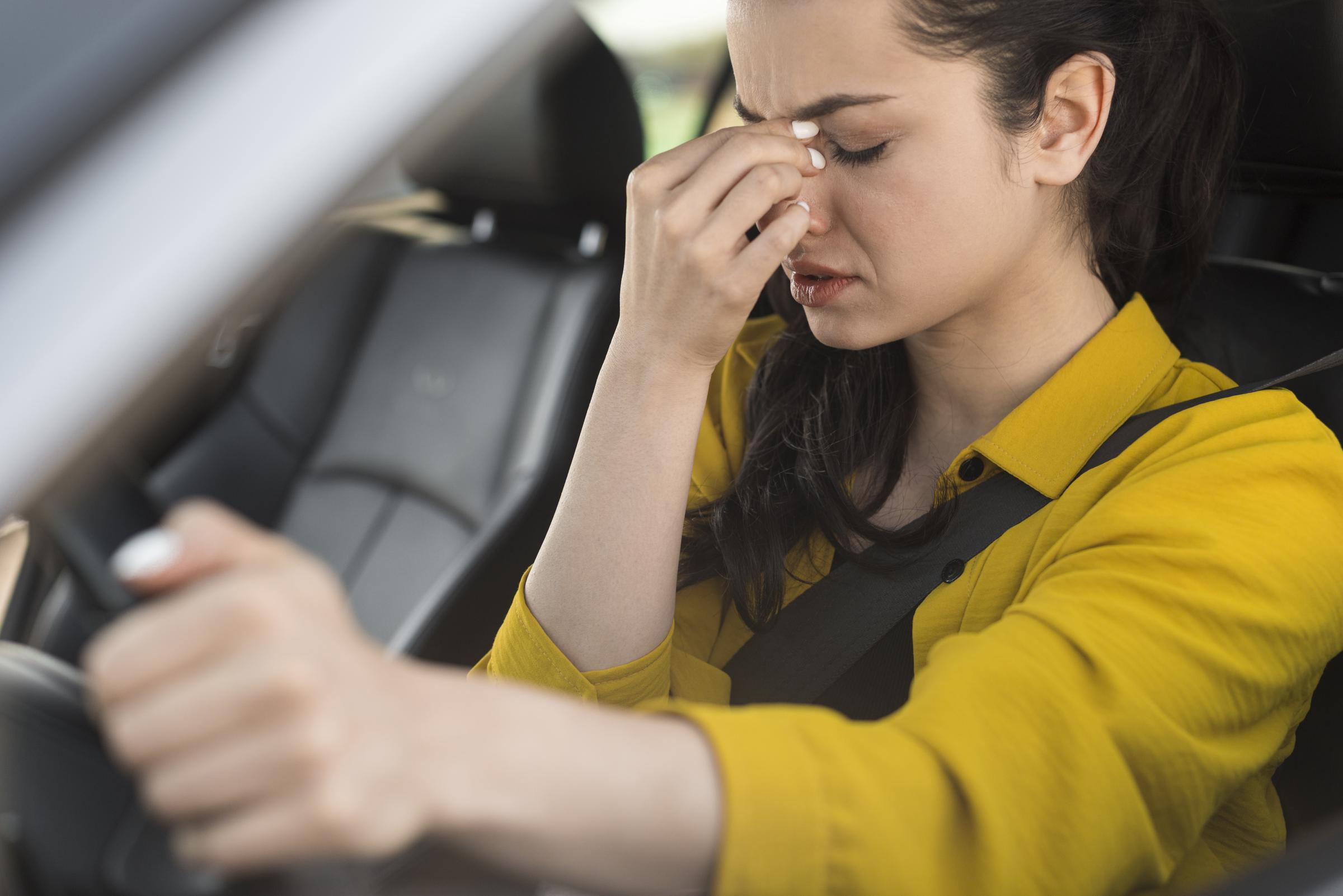 Eine verzweifelte Frau am Steuer eines Autos | Quelle: Freepik