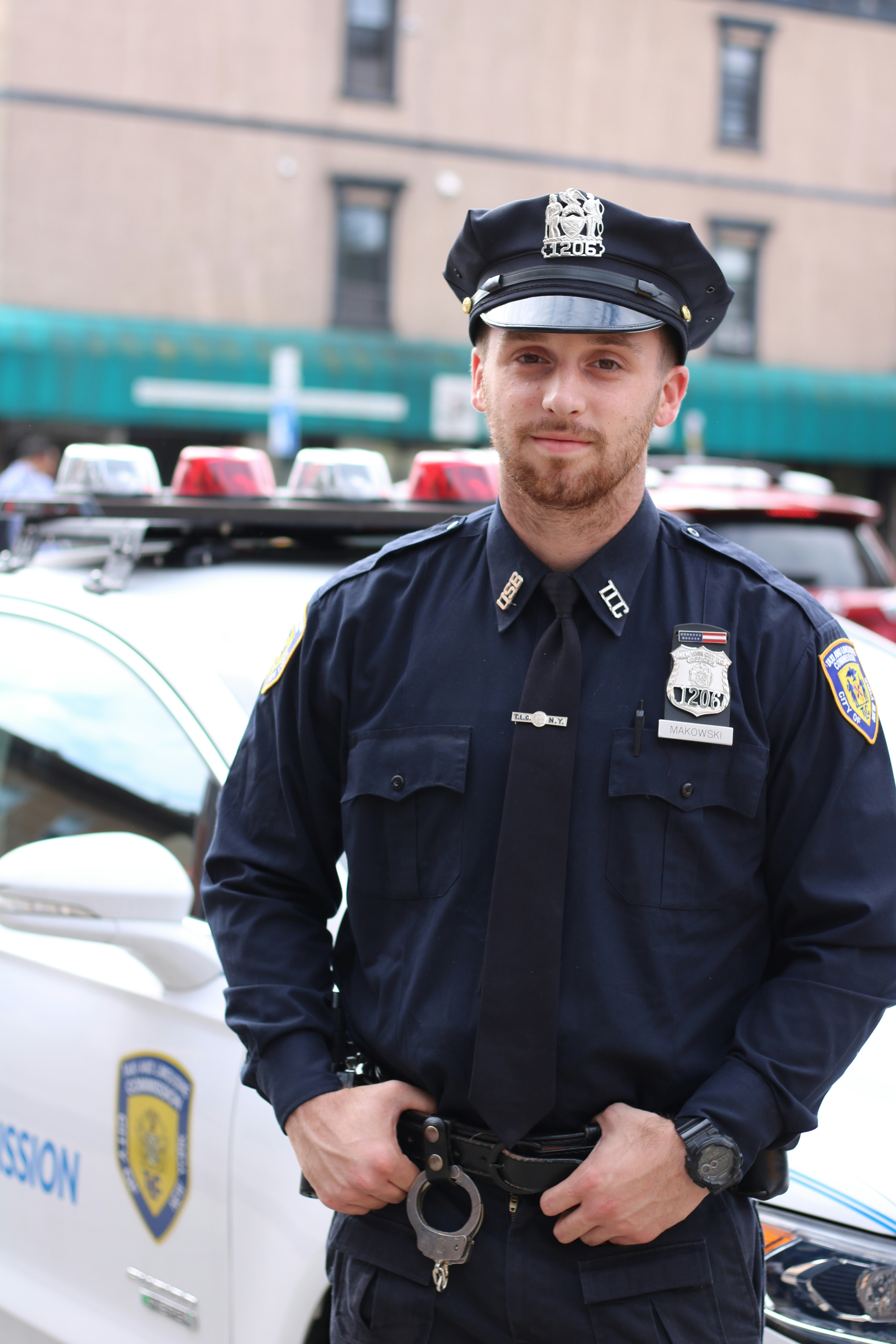 Polizist steht neben seinem Auto | Quelle: Unsplash