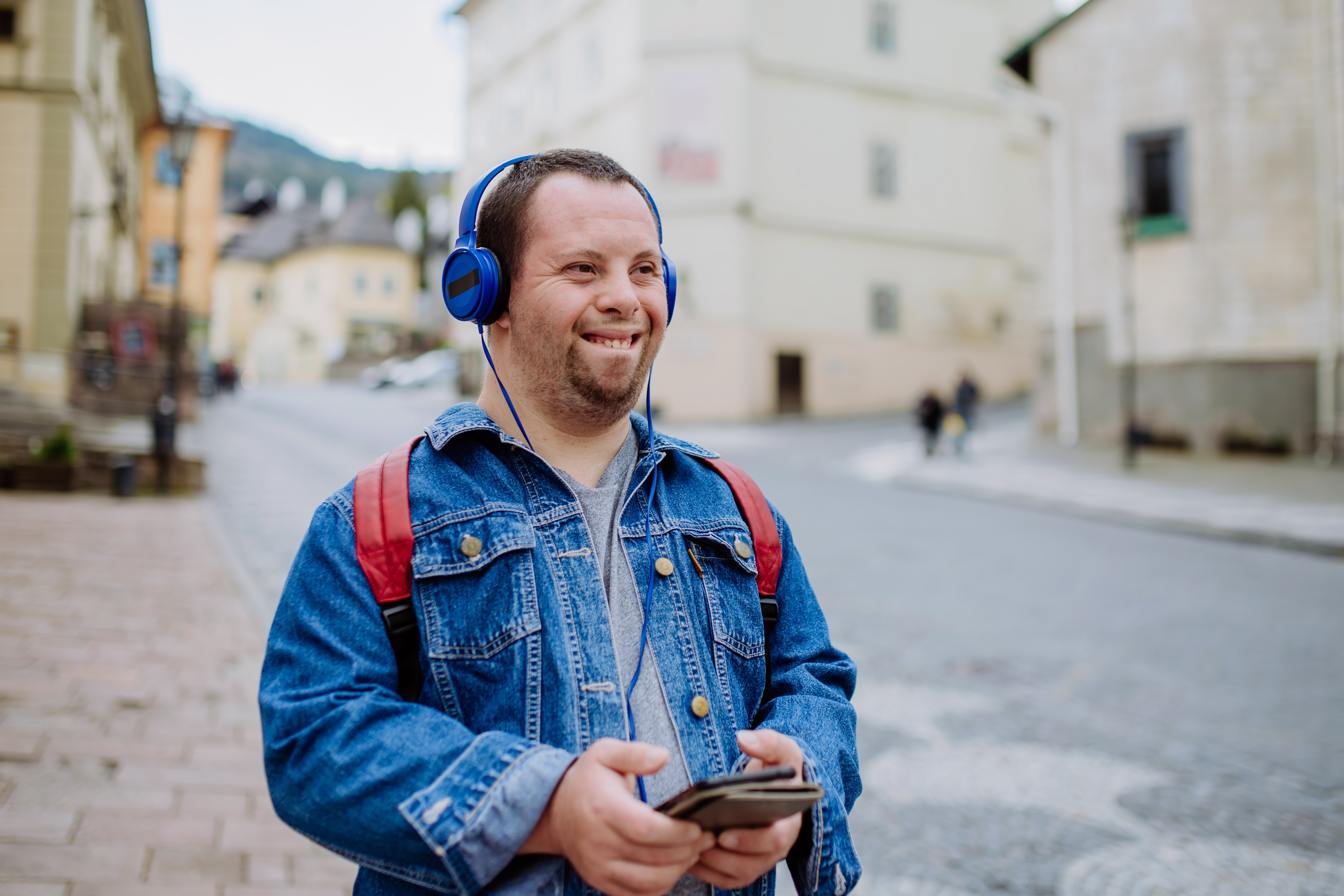Ein Mann mit Down-Syndrom hört Musik, während er auf der Straße geht. | Quelle: Shutterstock