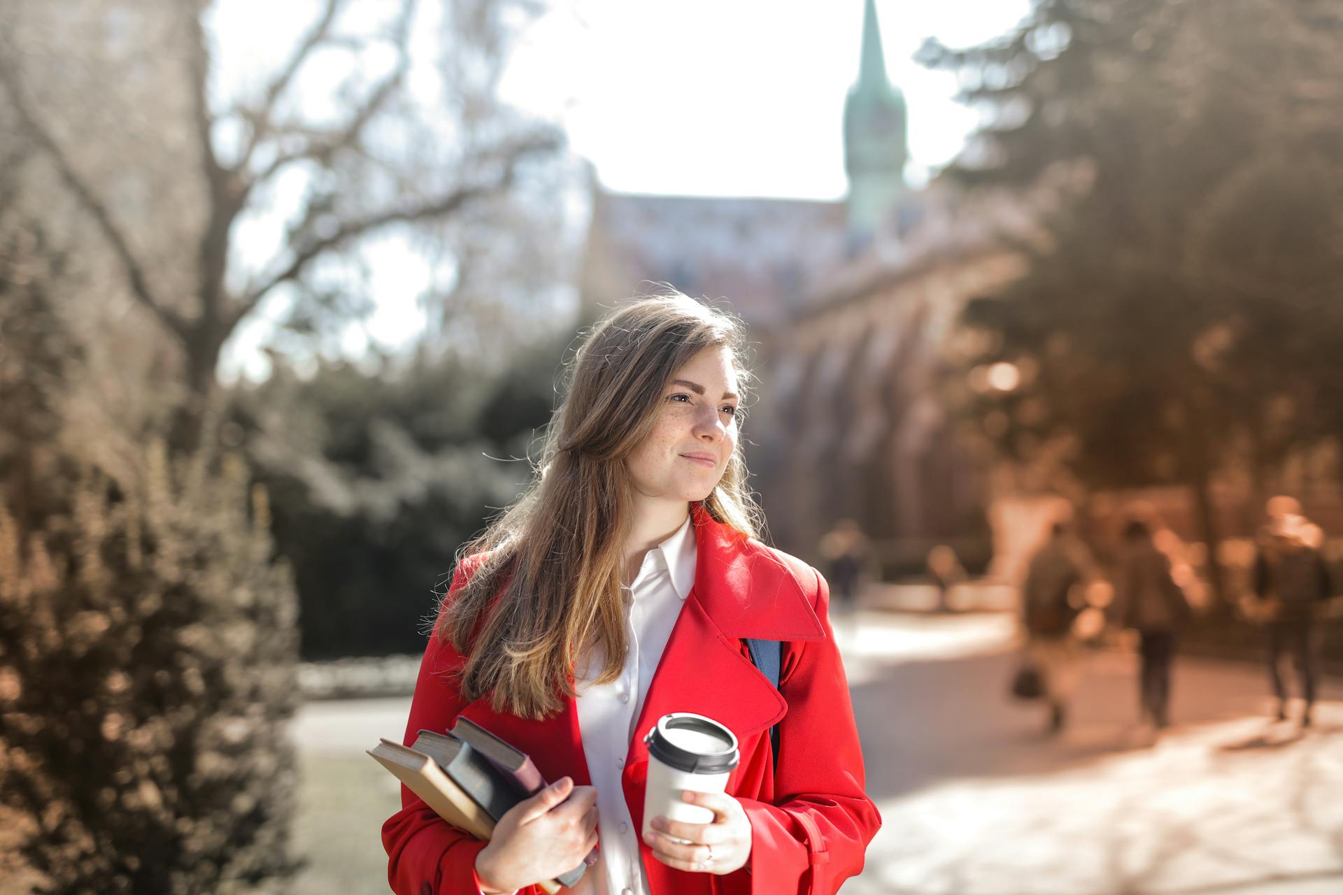 Eine Frau auf einem College-Campus, die Bücher trägt | Quelle: Pexels