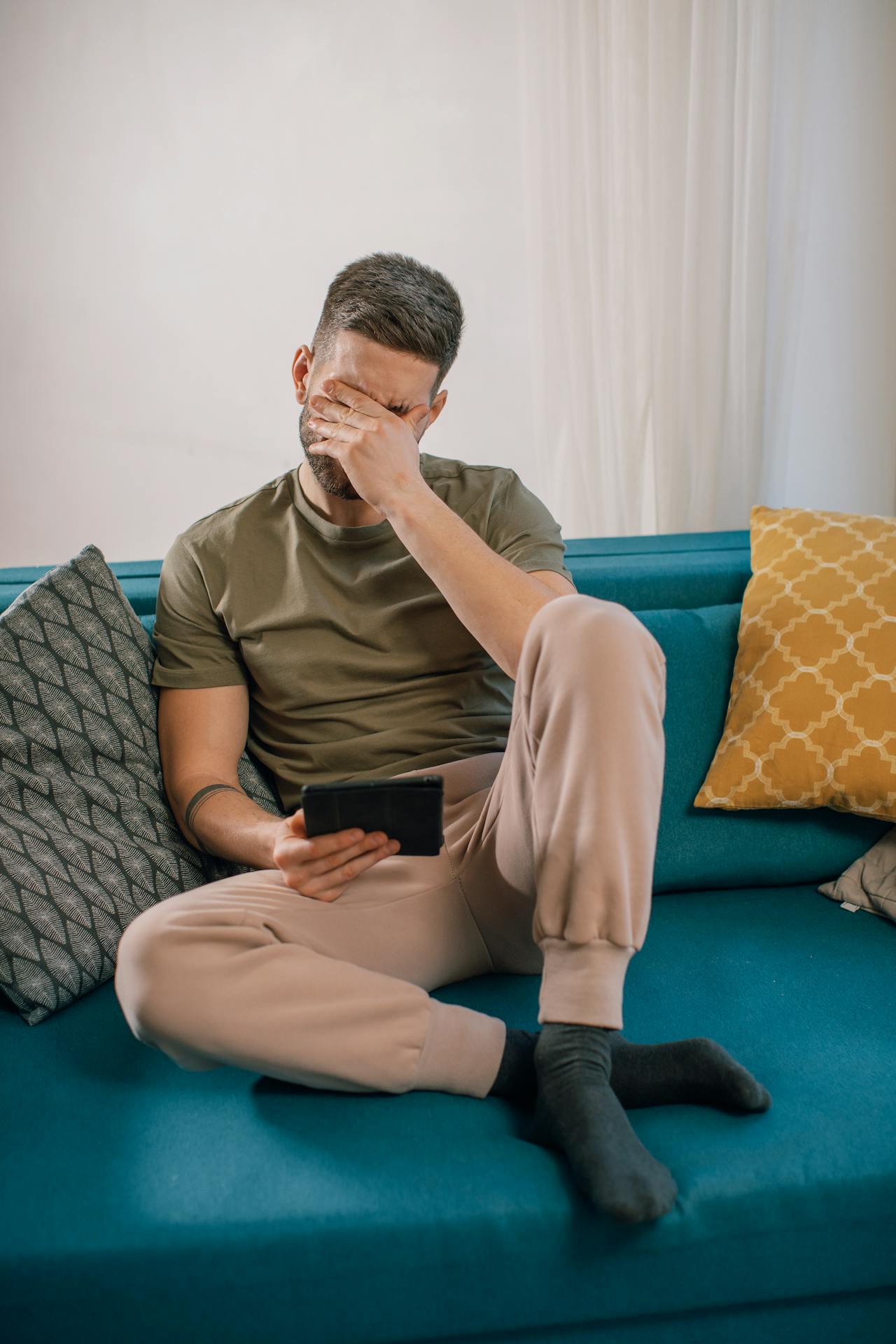 Ein genervter Mann sitzt auf der Couch | Quelle: Pexels