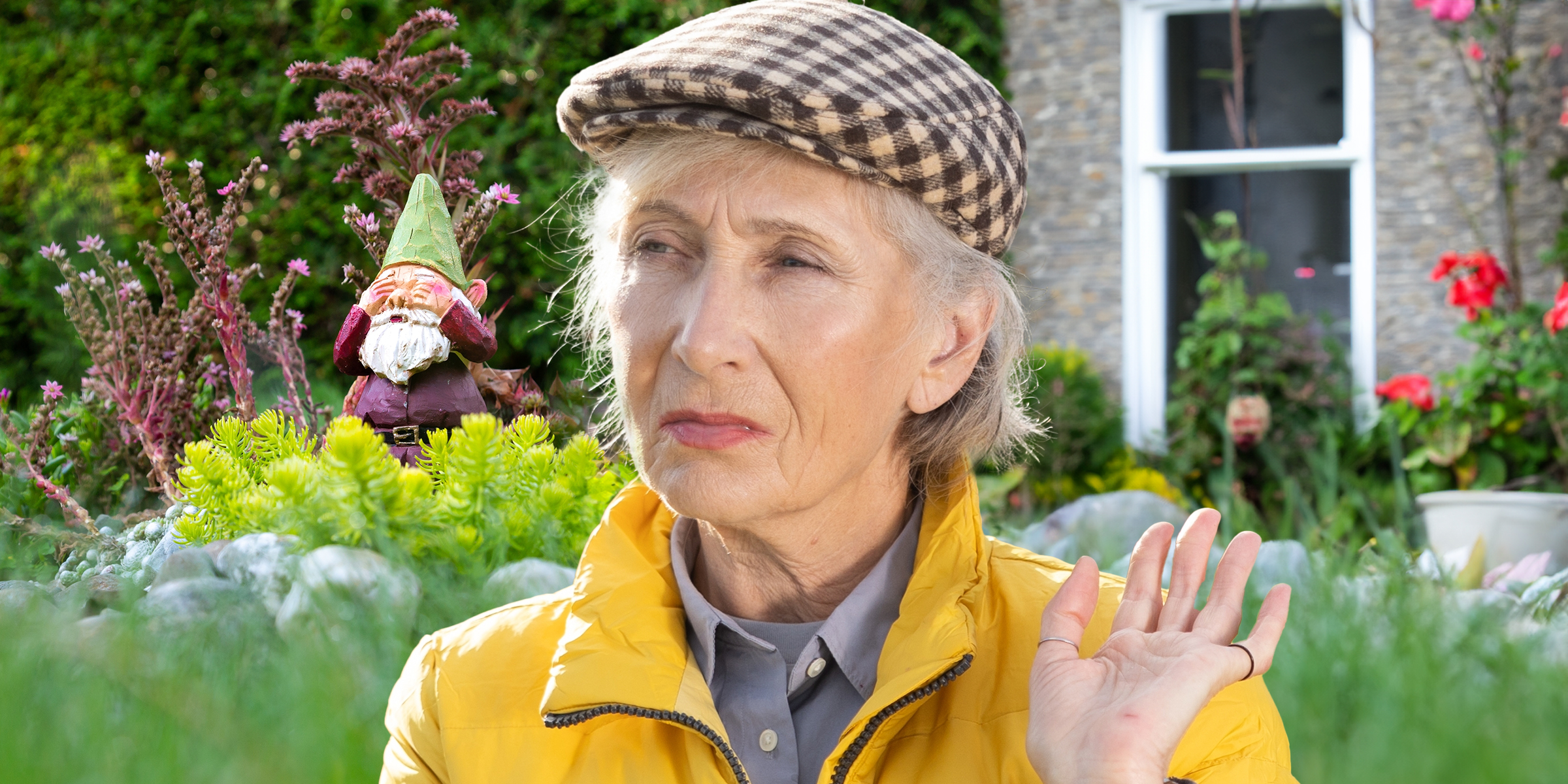 Eine ältere Frau mit einem Gartenzwerg im Hintergrund | Quelle: Shutterstock