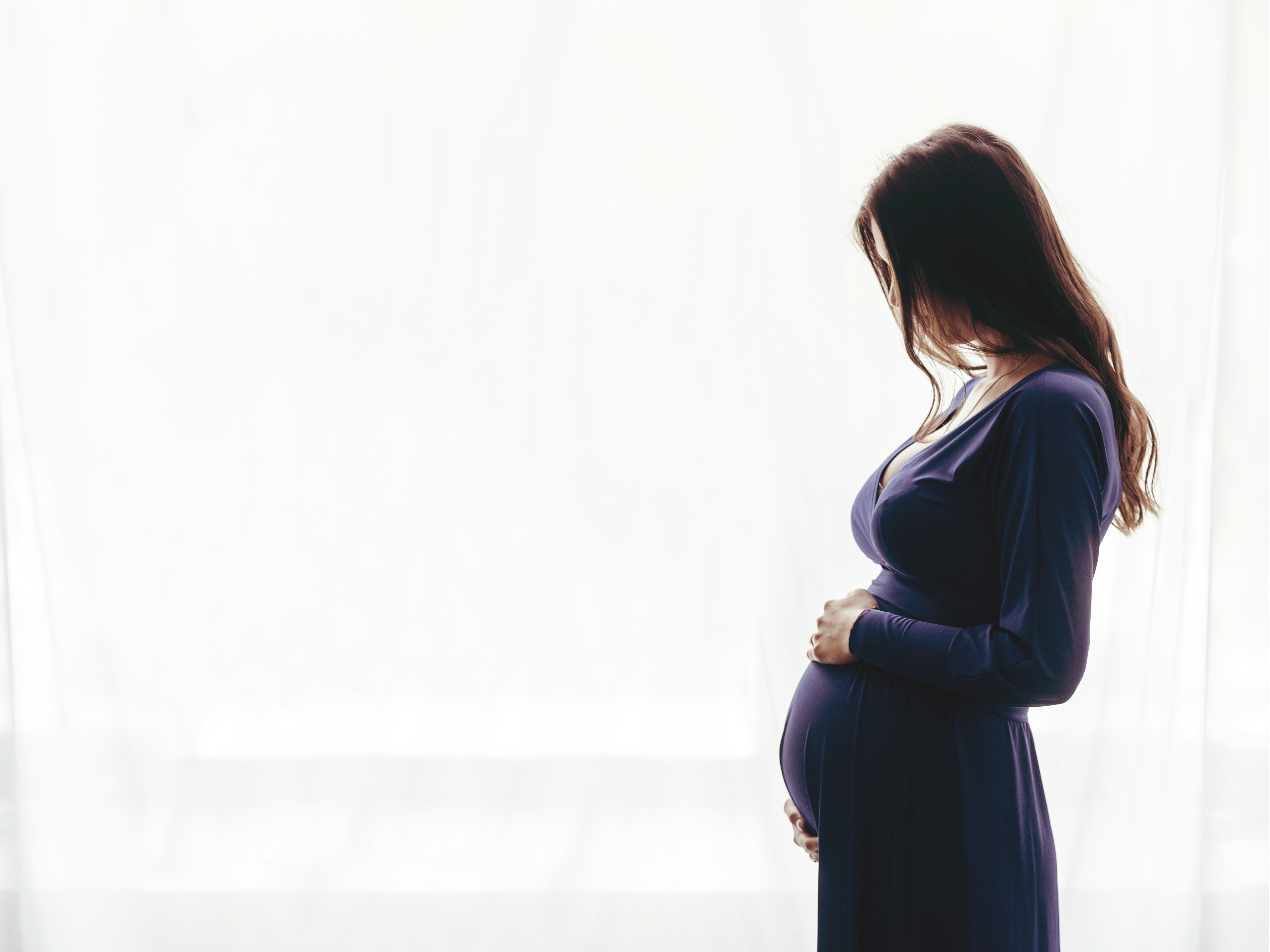 Eine schwangere Frau, die ihren Babybauch wiegt | Quelle: Shutterstock