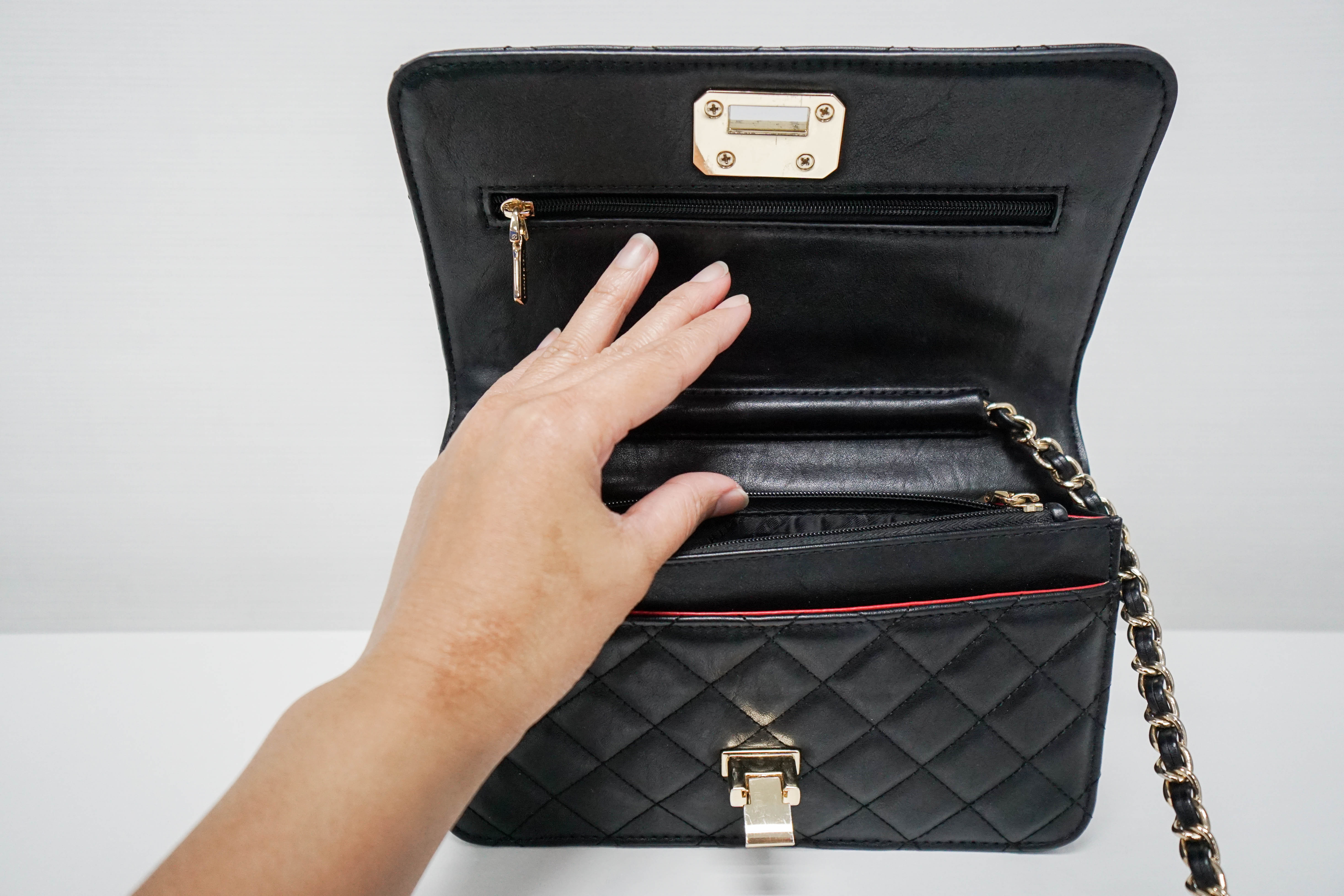 Eine Hand hält eine Handtasche offen | Quelle: Shutterstock