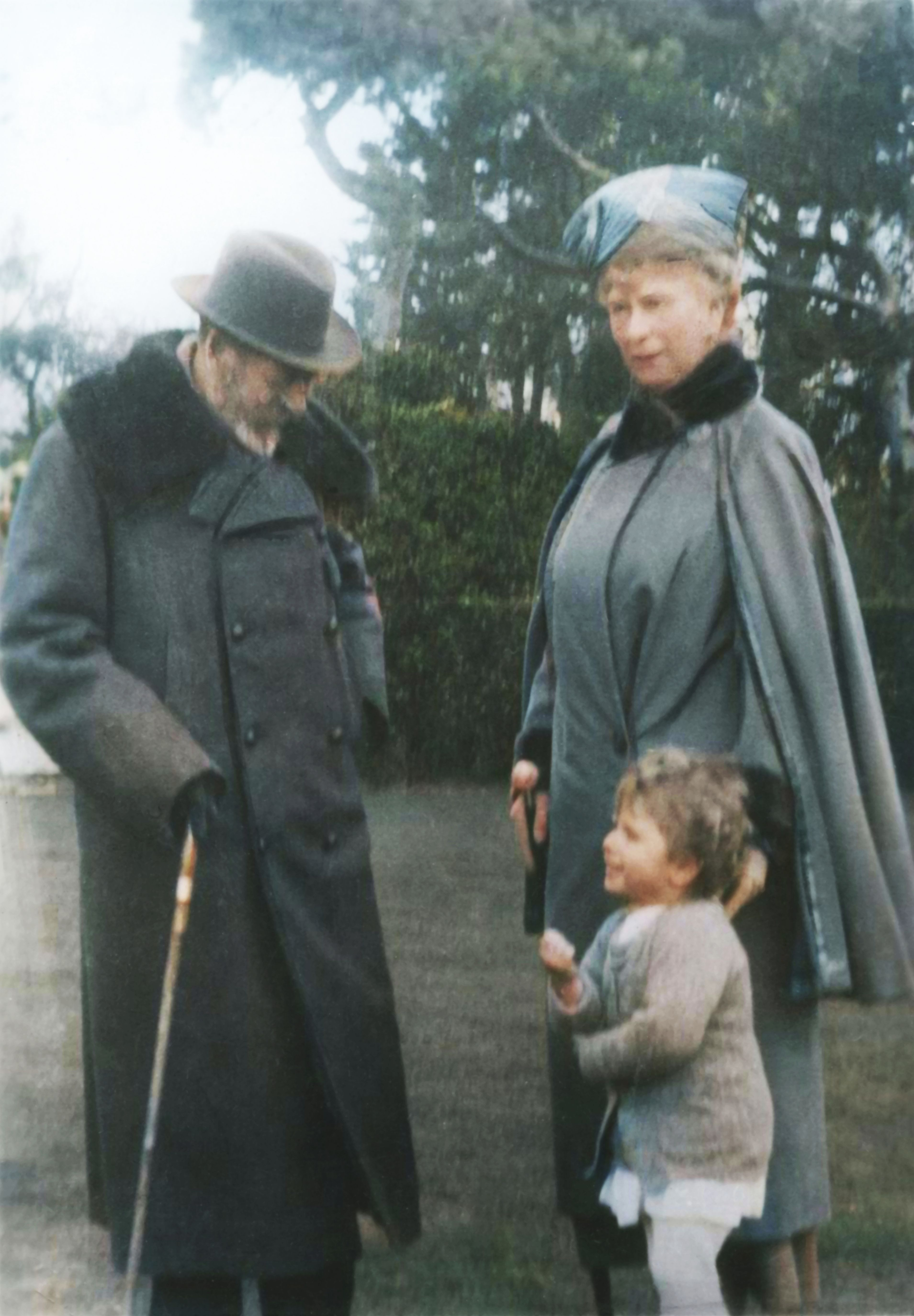 König Georg V. und Königin Mary wurden um 1930 zusammen mit ihrer kleinen Enkelin, der späteren Königin Elisabeth II., fotografiert. Georg V. hatte 1917 „Windsor“ sowohl als Namen des Königshauses als auch als Nachnamen seiner Familie angenommen und damit das moderne Namenssystem eingeführt, das Elisabeth später übernehmen sollte. | Quelle: Getty Images