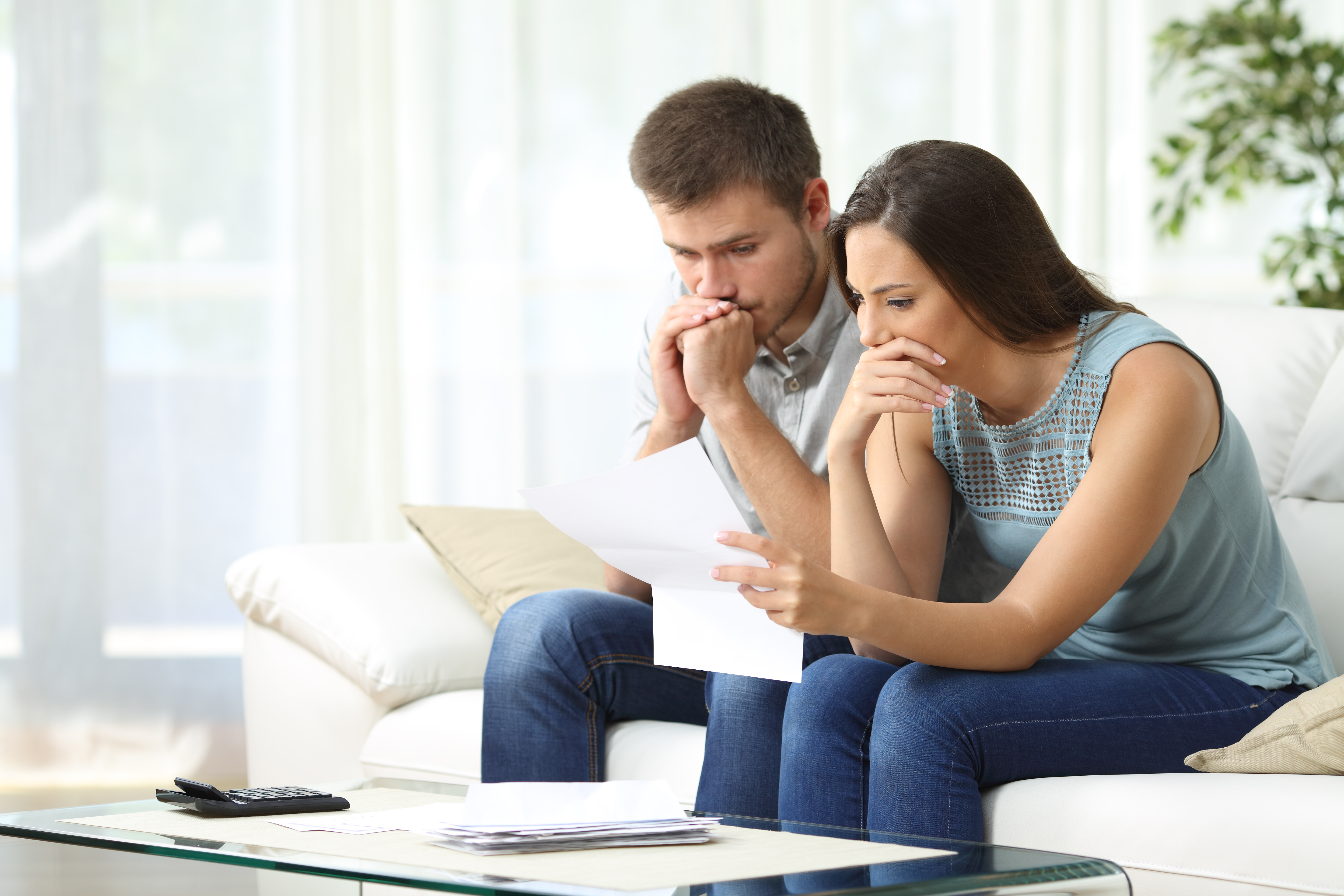 Ein besorgtes Paar sieht sich ein Dokument an | Quelle: Shutterstock