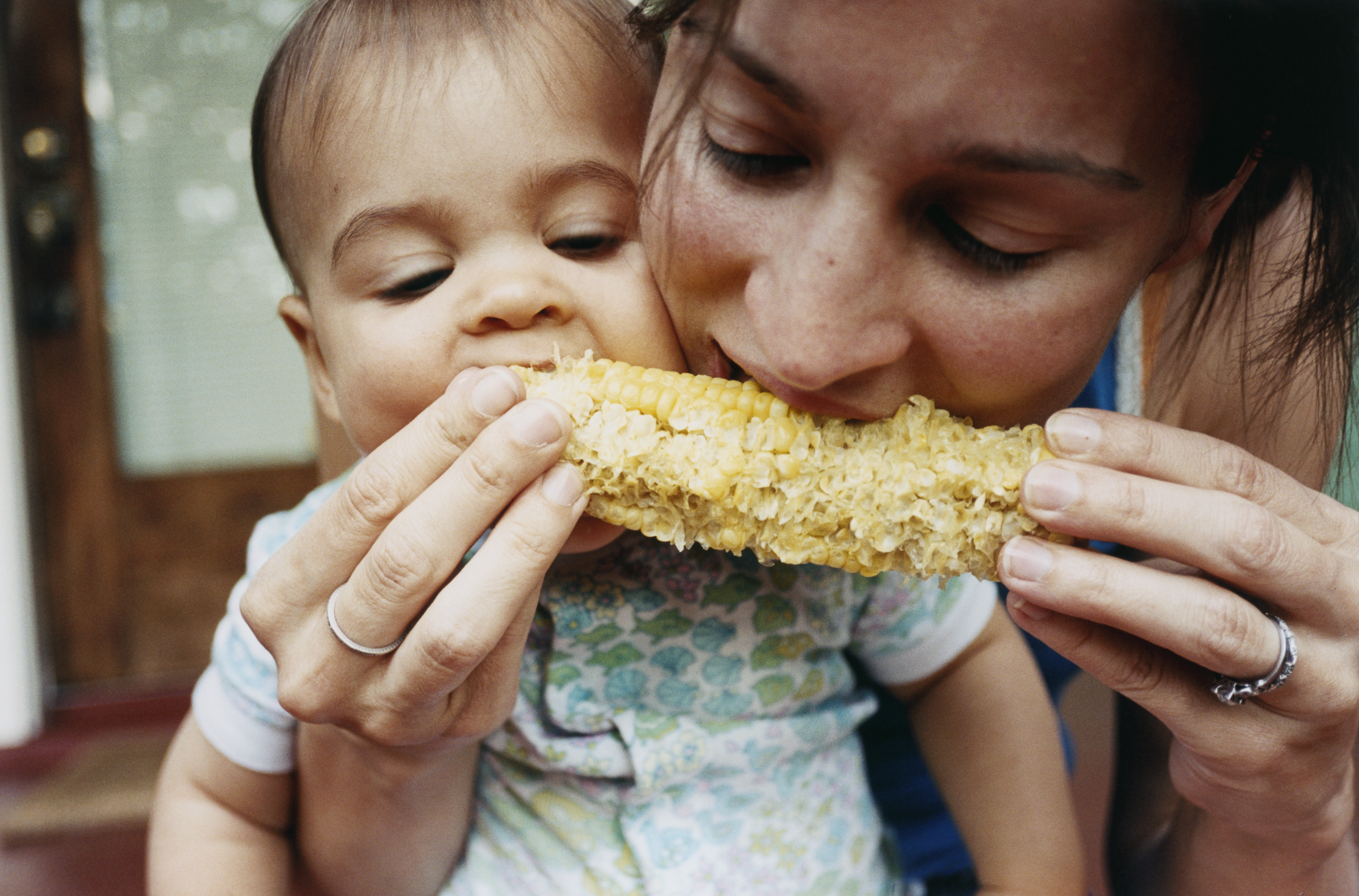 Eine Mutter und ihr Baby essen Mais | Quelle: Getty Images