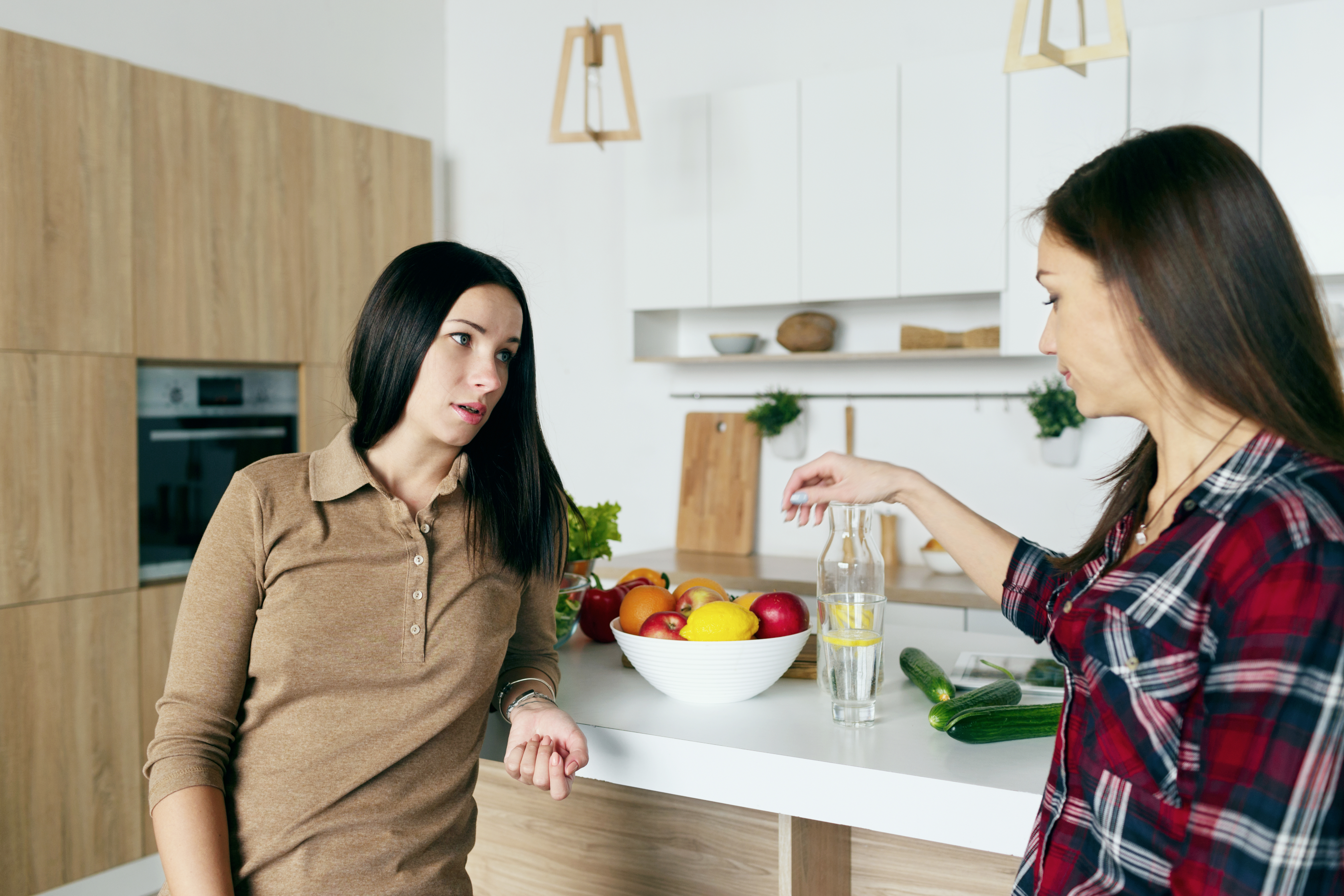 Zwei Frauen unterhalten sich in der Küche | Quelle: Shutterstock