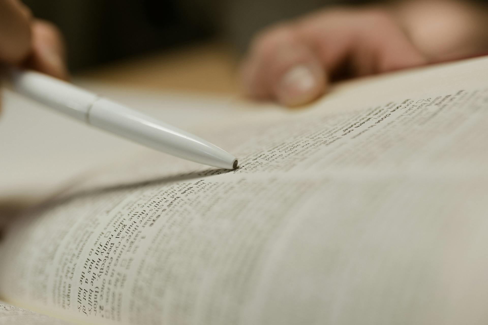 Eine Person studiert einen Text in einem Buch | Quelle: Pexels