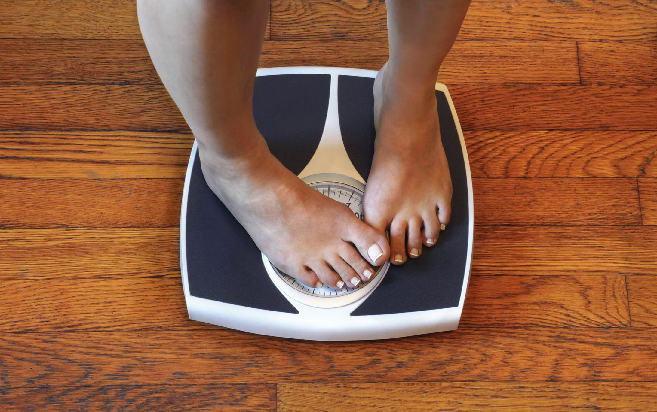 Frau auf der Waage unzufrieden mit ihrem Gewicht. I Quelle: Getty Images