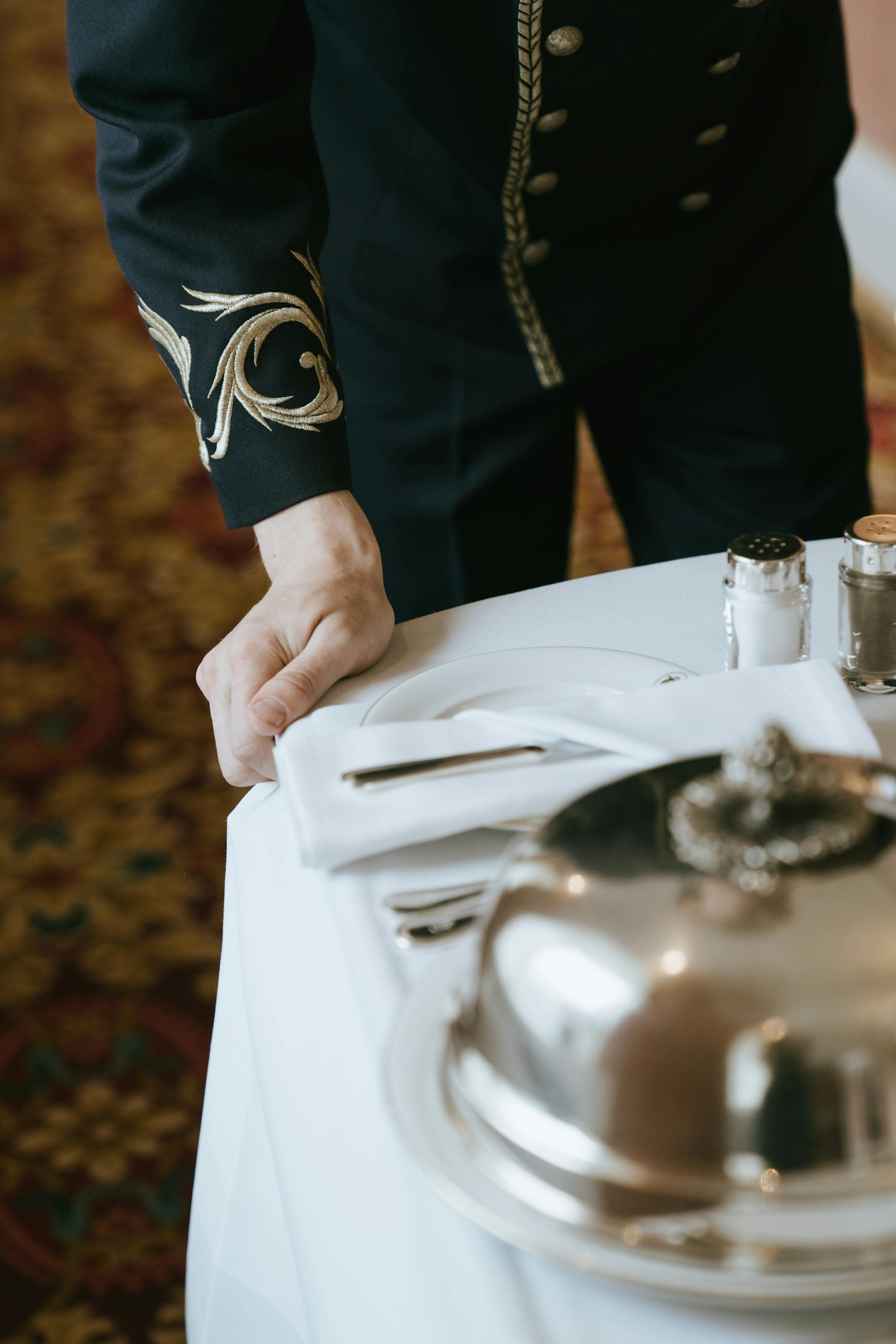 Ausgeschnittene Aufnahme eines Butlers, der ein Tablett schiebt | Quelle: Pexels