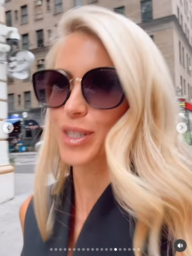 Katie Zacharia spaziert durch eine Straße in der Stadt – sie trägt eine übergroße dunkle Sonnenbrille und ein schwarzes, ärmelloses Outfit, ihr blondes Haar fällt ihr über die Schultern. | Quelle: Instagram/katiezacharia
