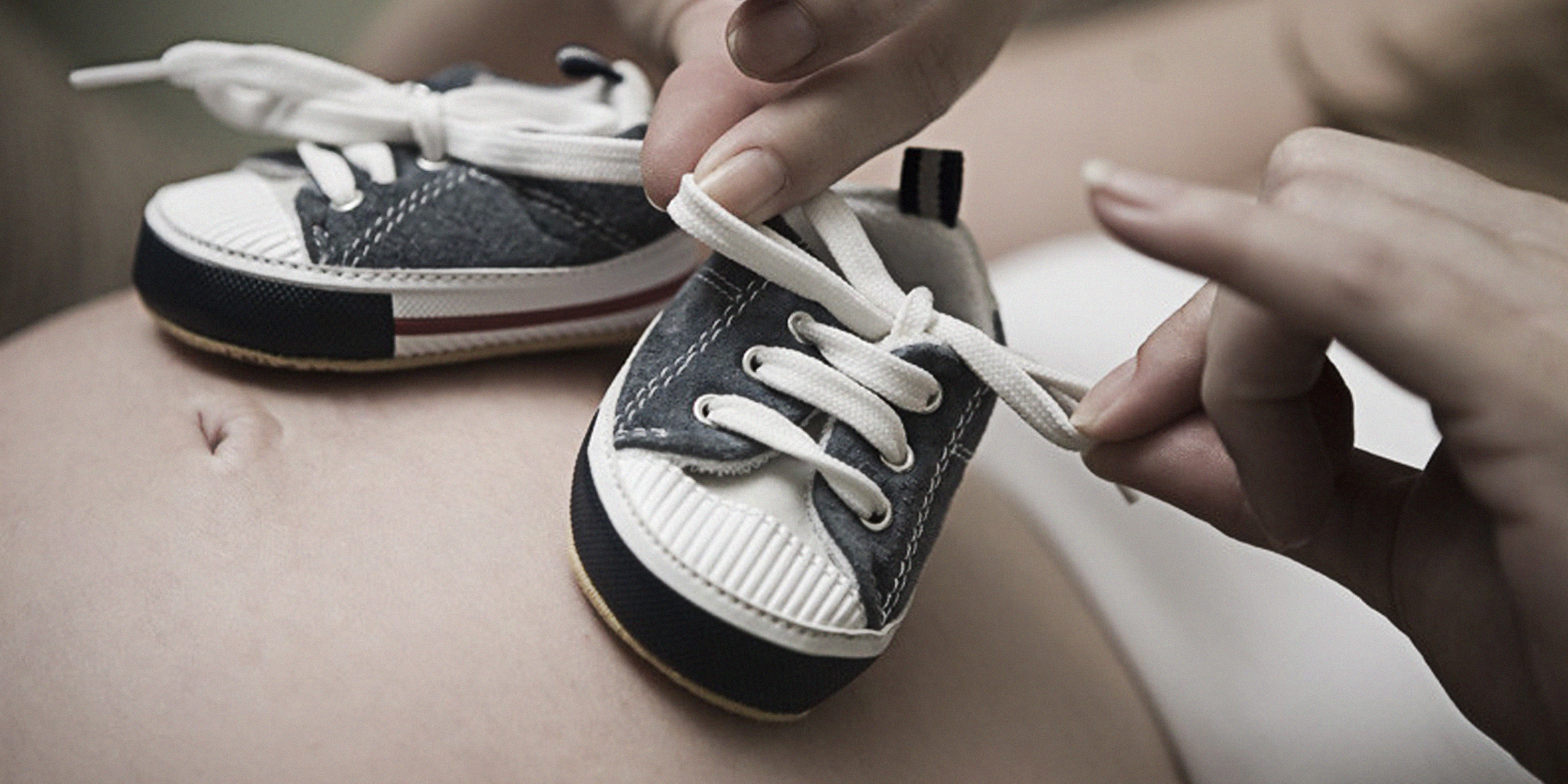 Babyschuhe auf dem Bauch einer schwangeren Frau | Quelle: flickr.com/Ⅿeagan/CC BY 2.0