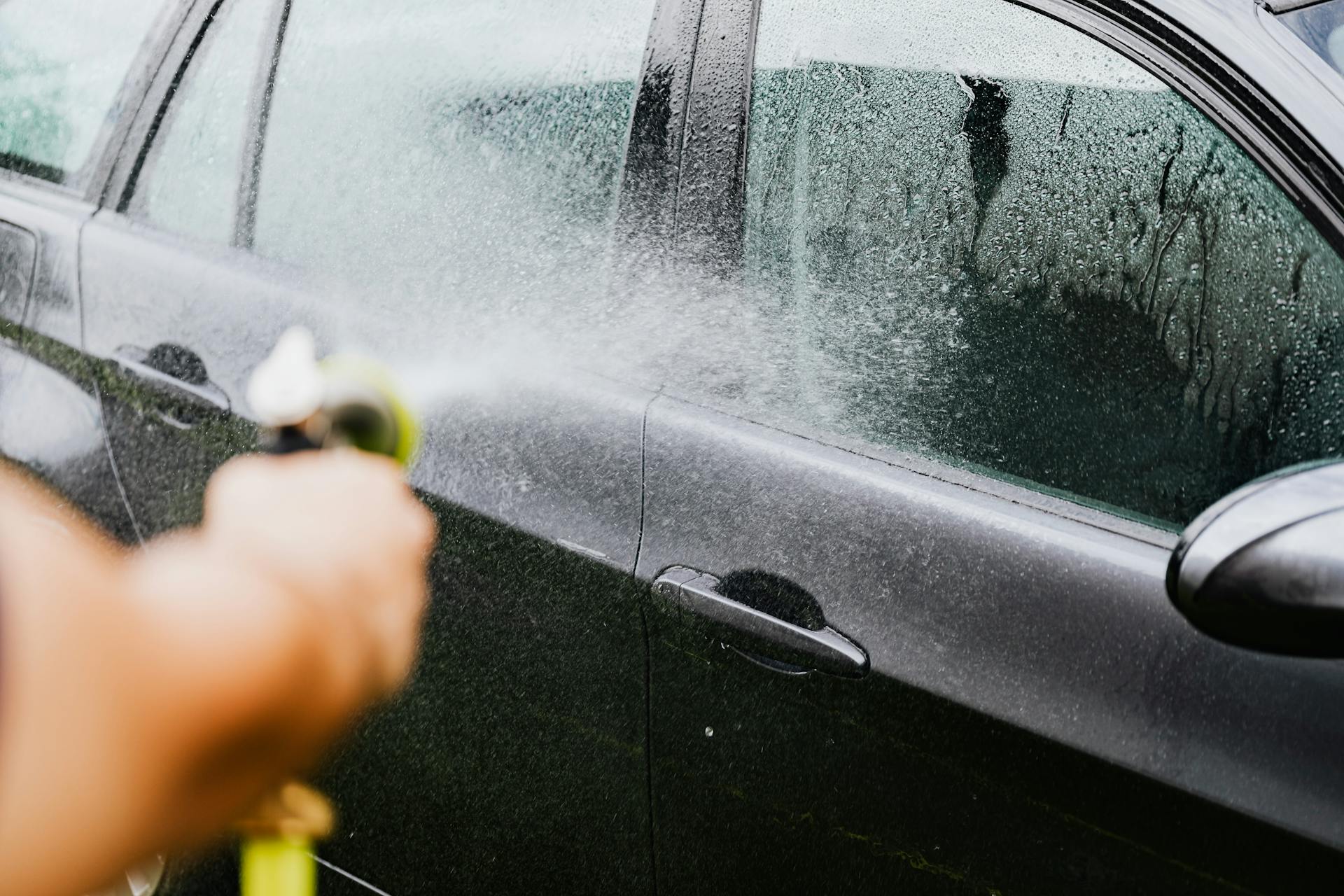 Eine Person wäscht ein Auto | Quelle: Pexels