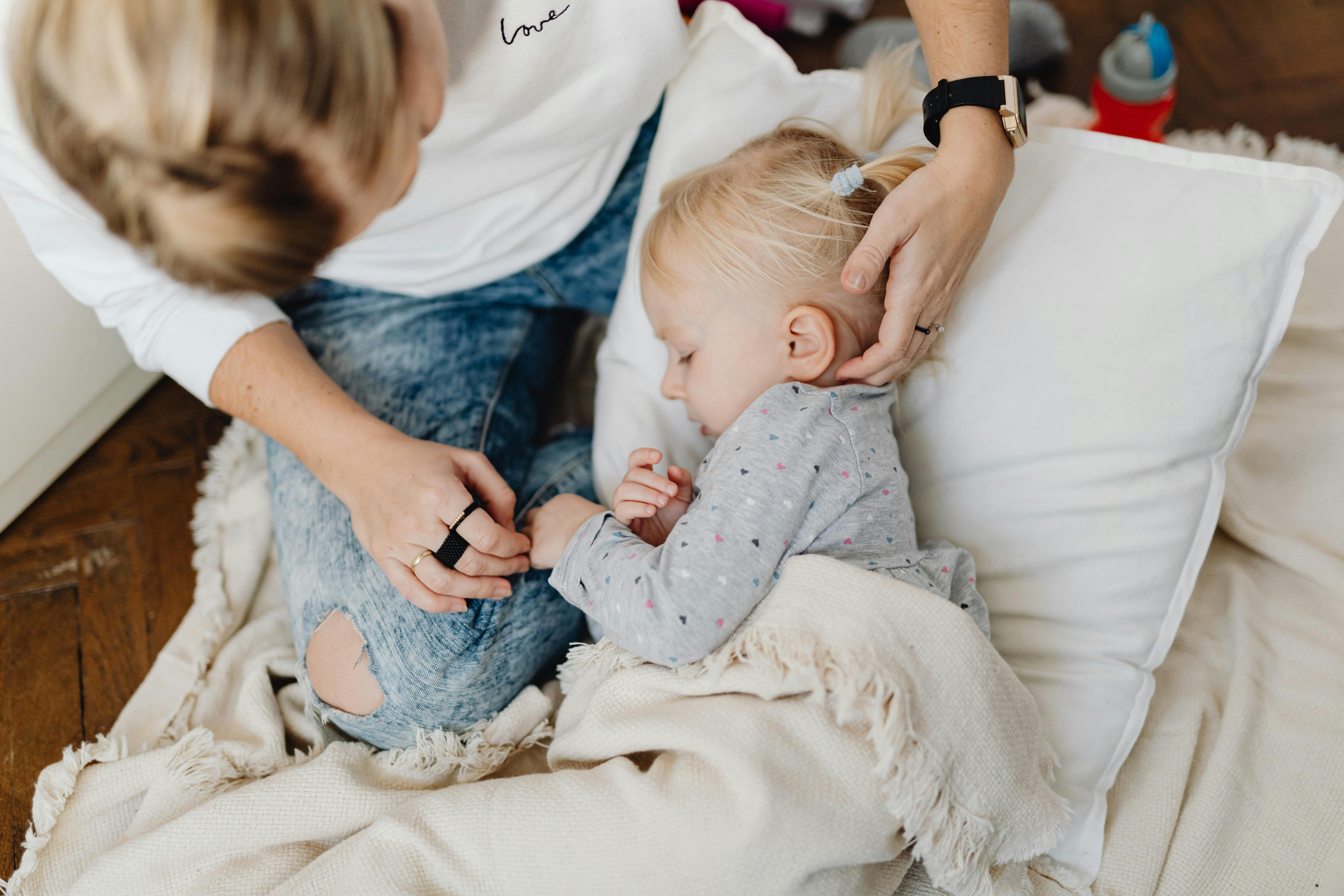 Frau, die ihre Tochter ins Bett bringt | Quelle: Pexels