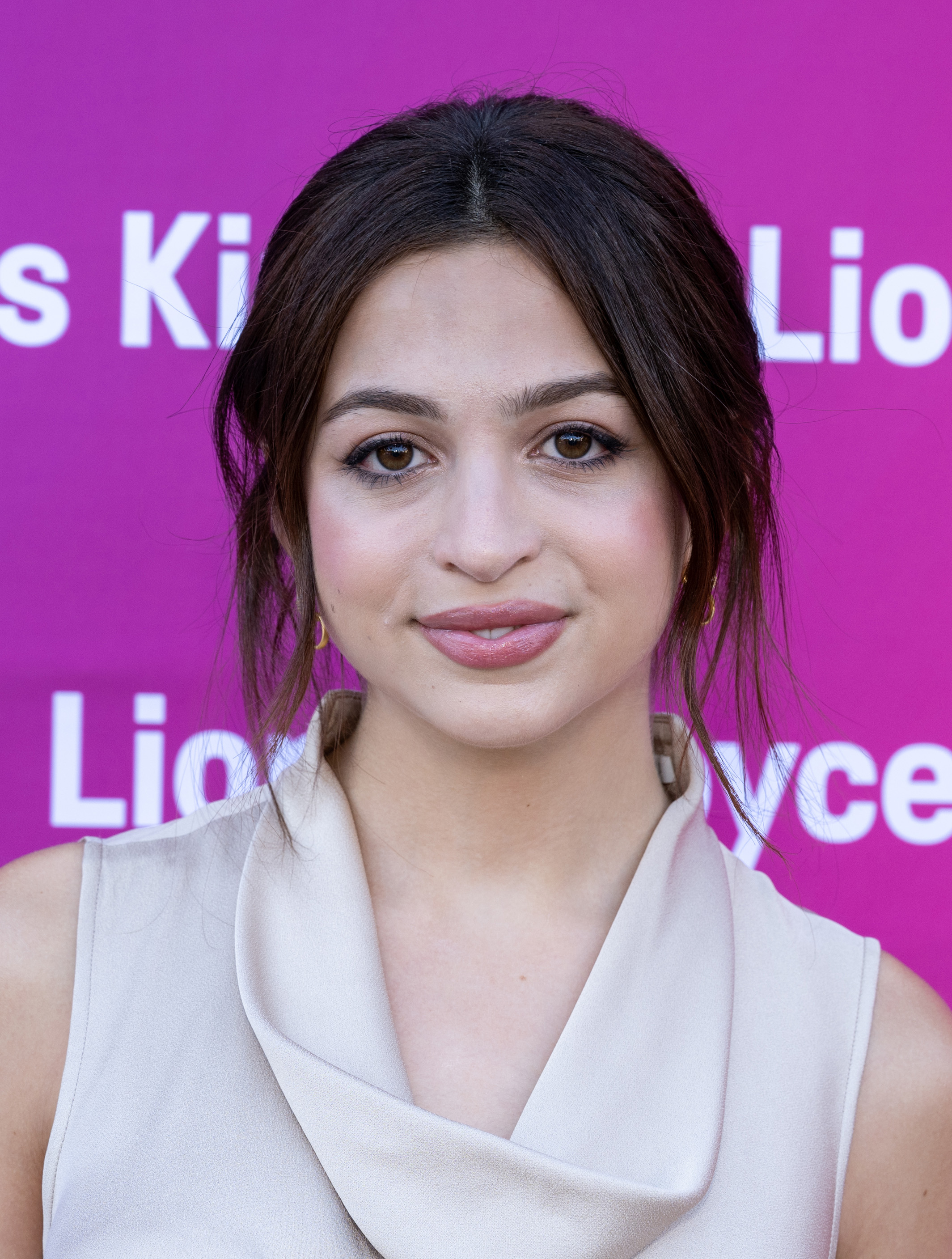 Josie Totah posiert bei der Veranstaltung „Film Independent New Wave Actors Panel and Conversation“ in einem ärmellosen, hellen Outfit mit drapiertem Ausschnitt. Ihr dunkles Haar ist zu einer lockeren Hochsteckfrisur gestylt, wobei einige Strähnen ihr Gesicht umrahmen. | Quelle: Getty Images