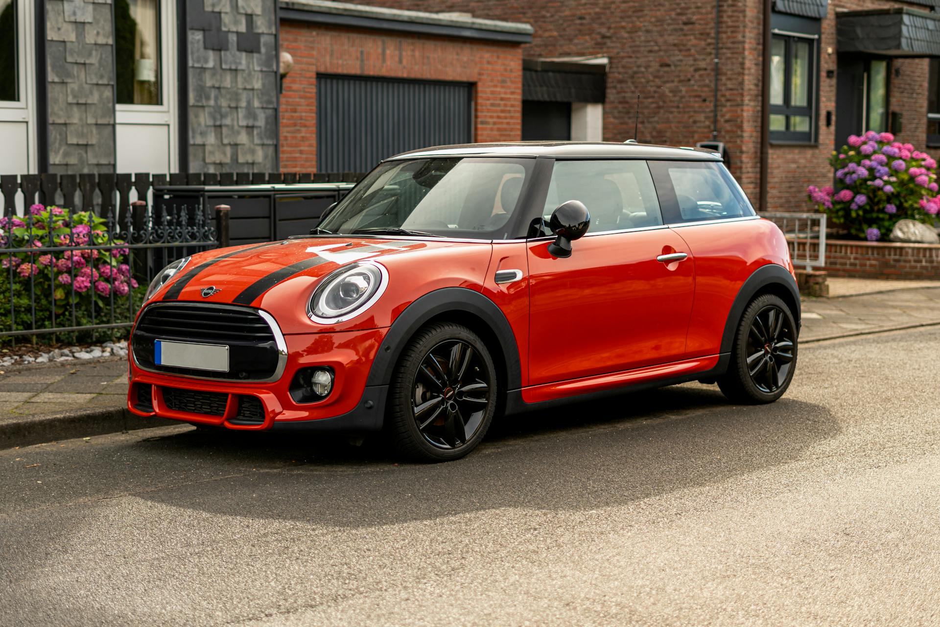 Ein roter Mini Cooper parkt vor einem Haus | Quelle: Pexels