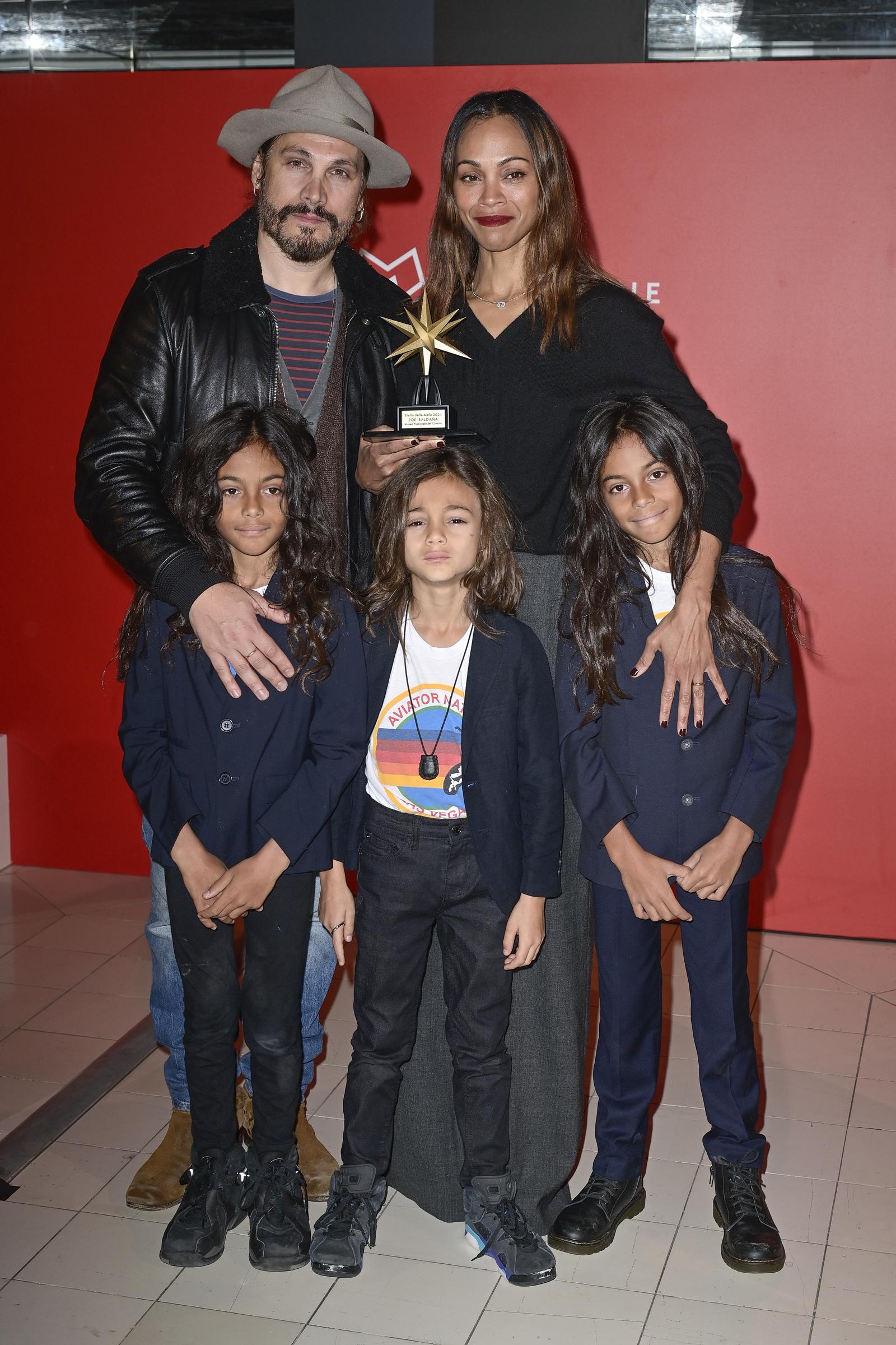 Marco Perego und Zoe Saldaña mit ihren Söhnen Cy, Bowie und Zen Perego-Saldaña beim Fotocall der „Emilia Perez“-Premiere. | Quelle: Getty Images