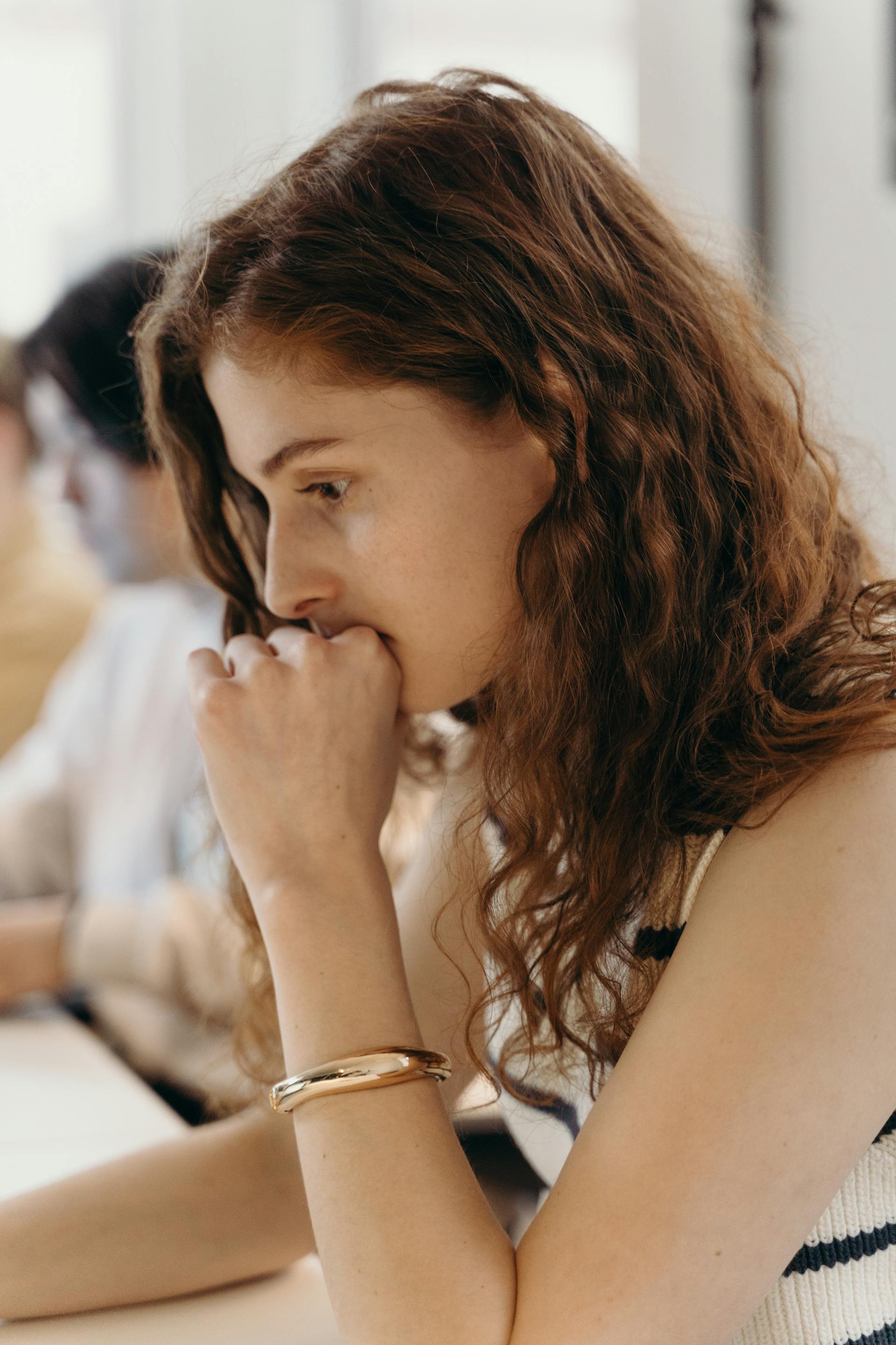 Eine nachdenkliche Frau sitzt an ihrem Schreibtisch in einem Büro | Quelle: Pexels