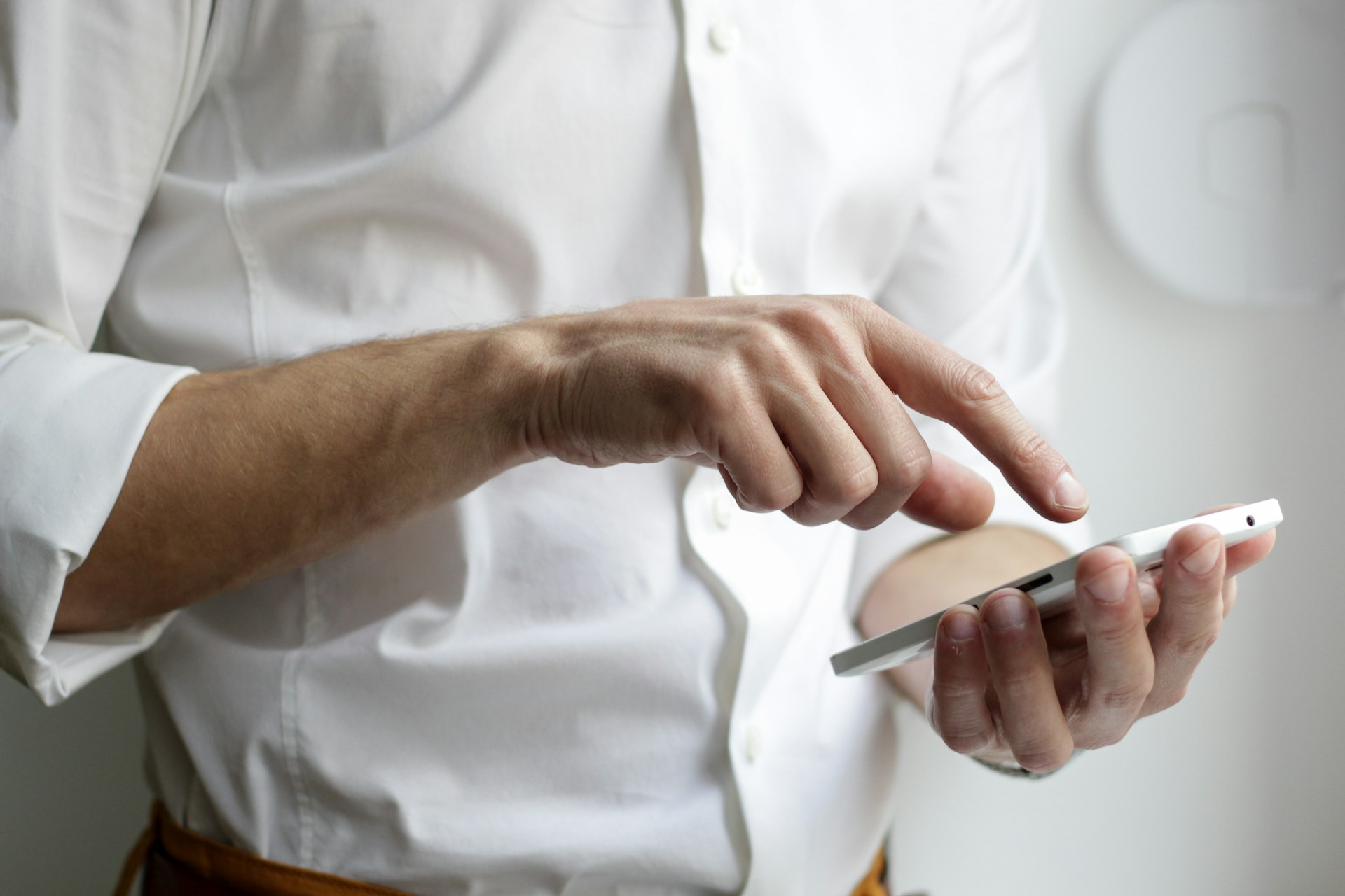 Nahaufnahme eines Mannes, der sein Telefon in der Hand hält | Quelle: Unsplash