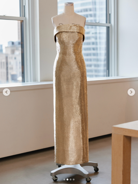 Das von Oscar de la Renta speziell für Usha Vance entworfene goldene Kleid mit Stabperlen ist im Atelier des Modehauses in New York City ausgestellt und bietet einen uneingeschränkten Blick auf den trägerlosen Ausschnitt und die bodenlange, schlanke Silhouette. | Quelle: Instagram/oscardelarenta