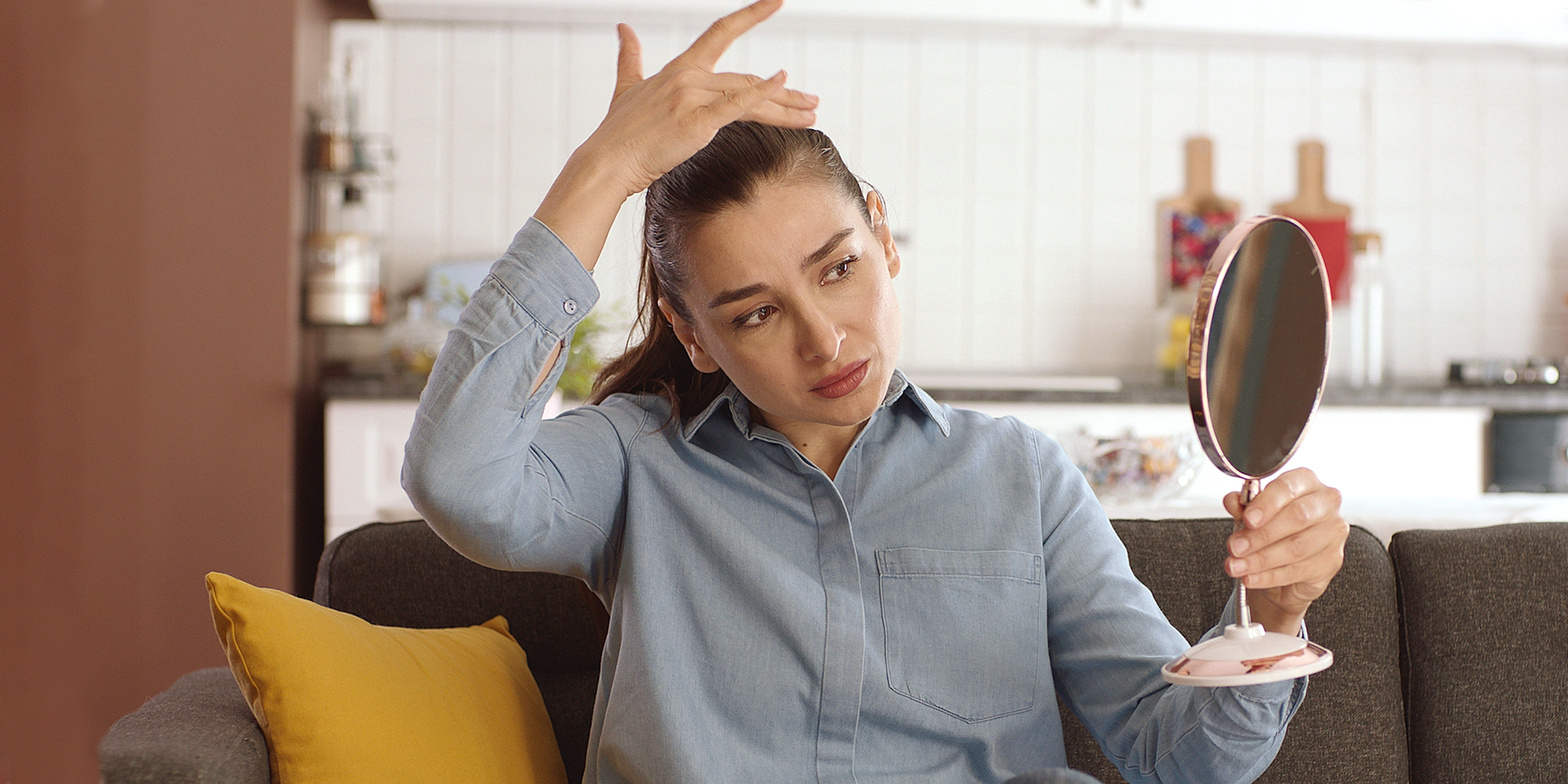 Eine Frau schaut in einen Spiegel | Quelle: Shutterstock