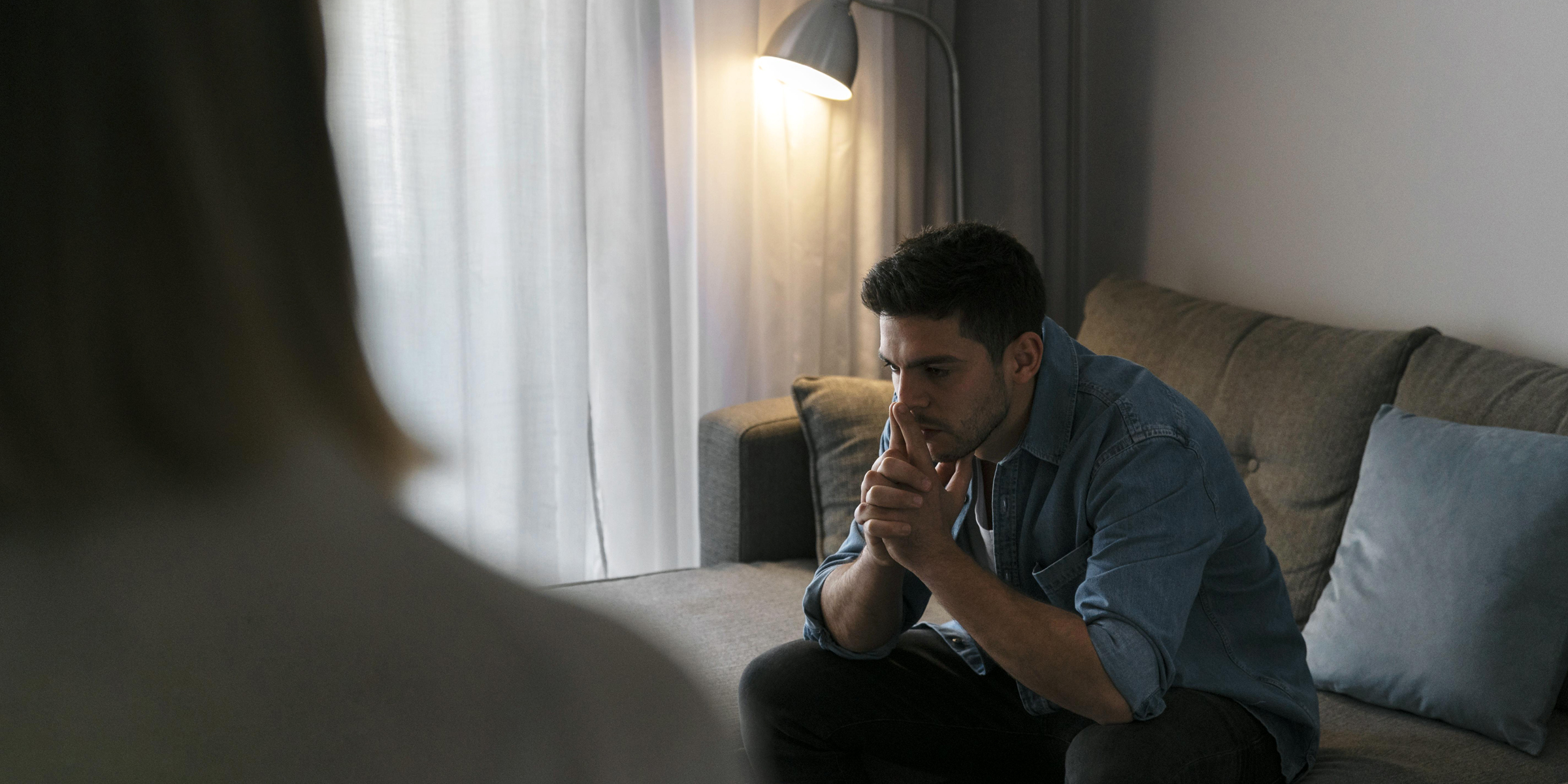 Ein emotionaler Mann sitzt auf einem Sofa | Quelle: Freepik