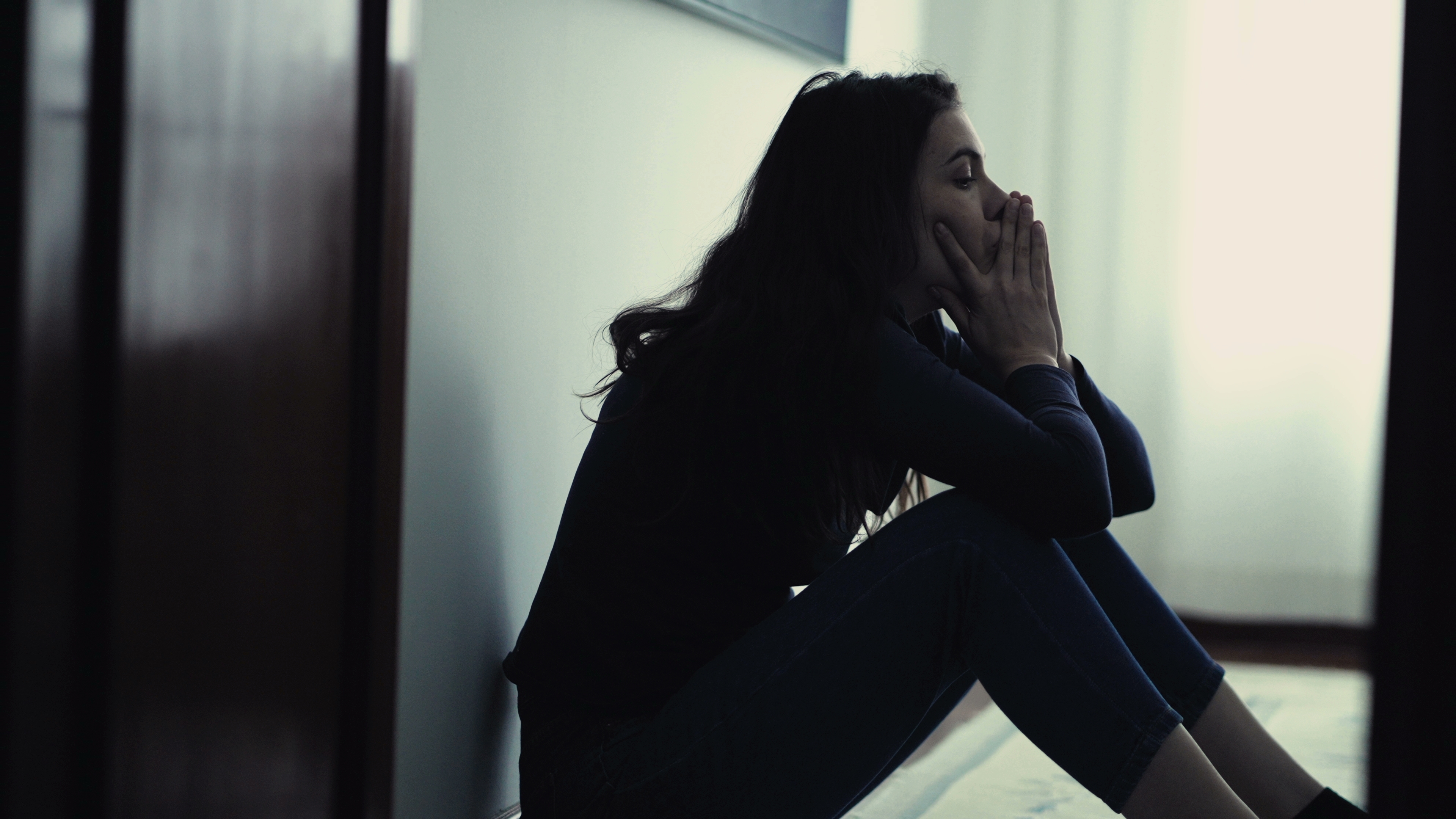 Eine depressive junge Frau, die alleine sitzt | Quelle: Shutterstock