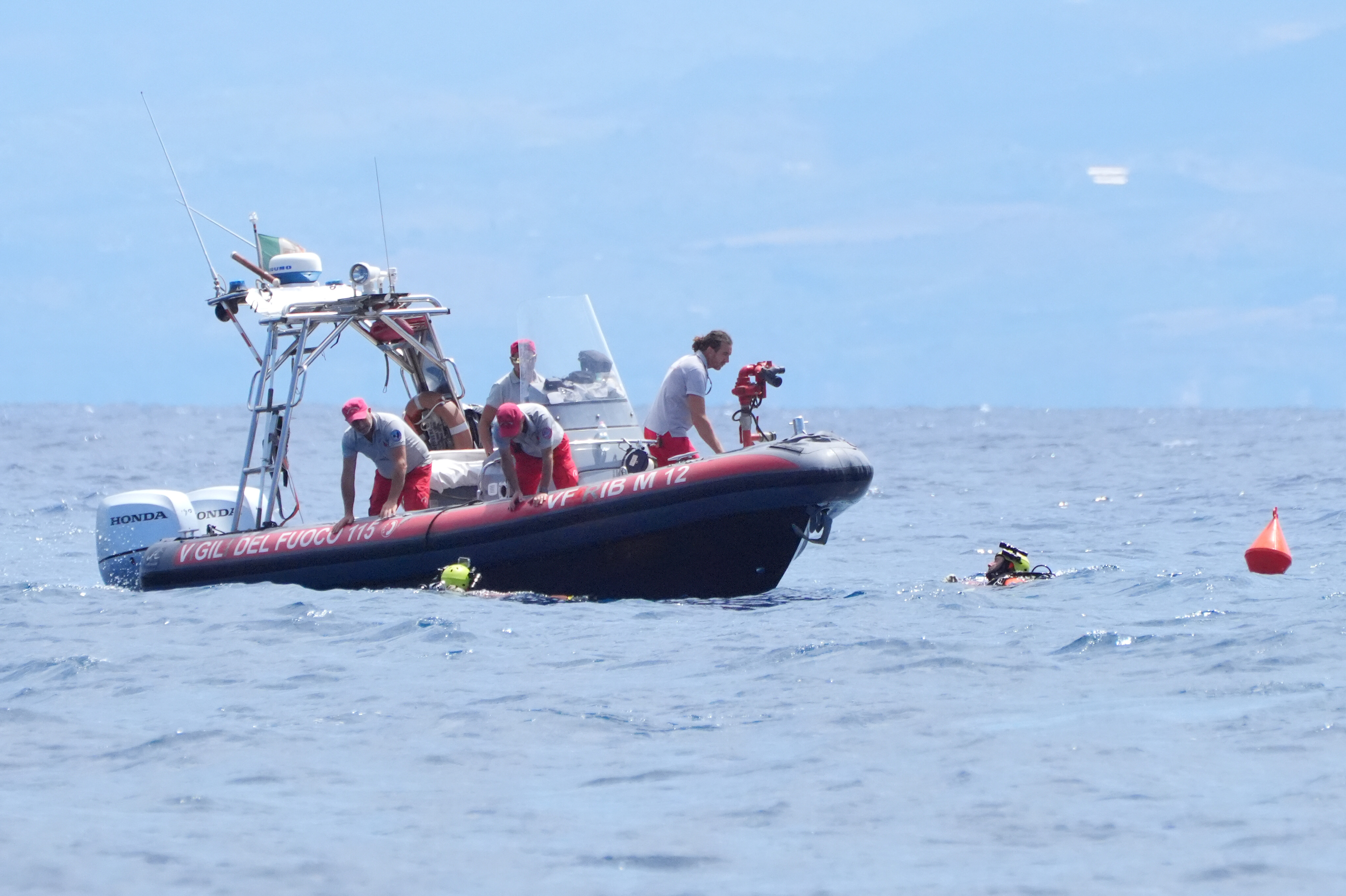 Eine italienische Feuerwehr-Tauchergruppe taucht am 21. August 2024 vor der Küste von Porticello, Sizilien, an ihrem Schlauchboot auf | Quelle: Getty Images