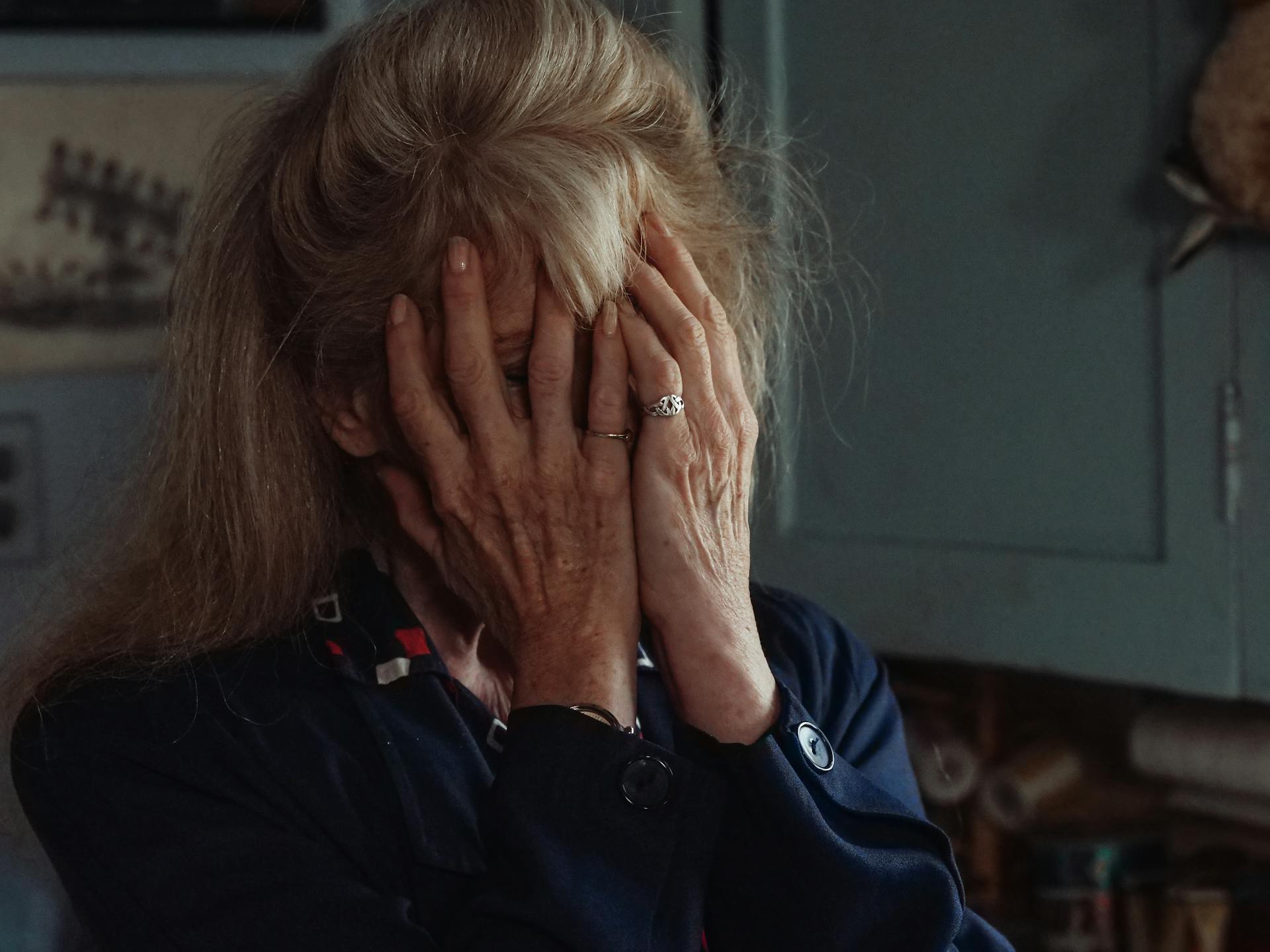 Eine ältere Frau, die ihr Gesicht bedeckt | Quelle: Pexels