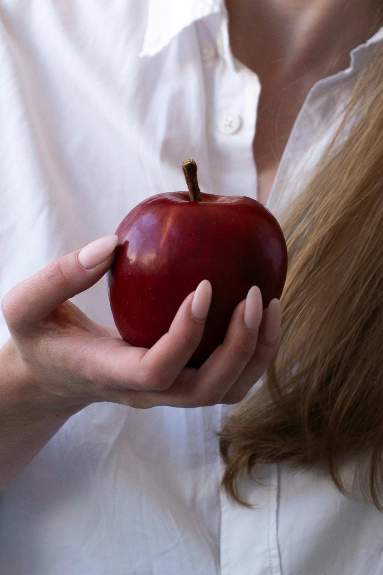 Eine Frau hält einen Apfel | Quelle: Pexels