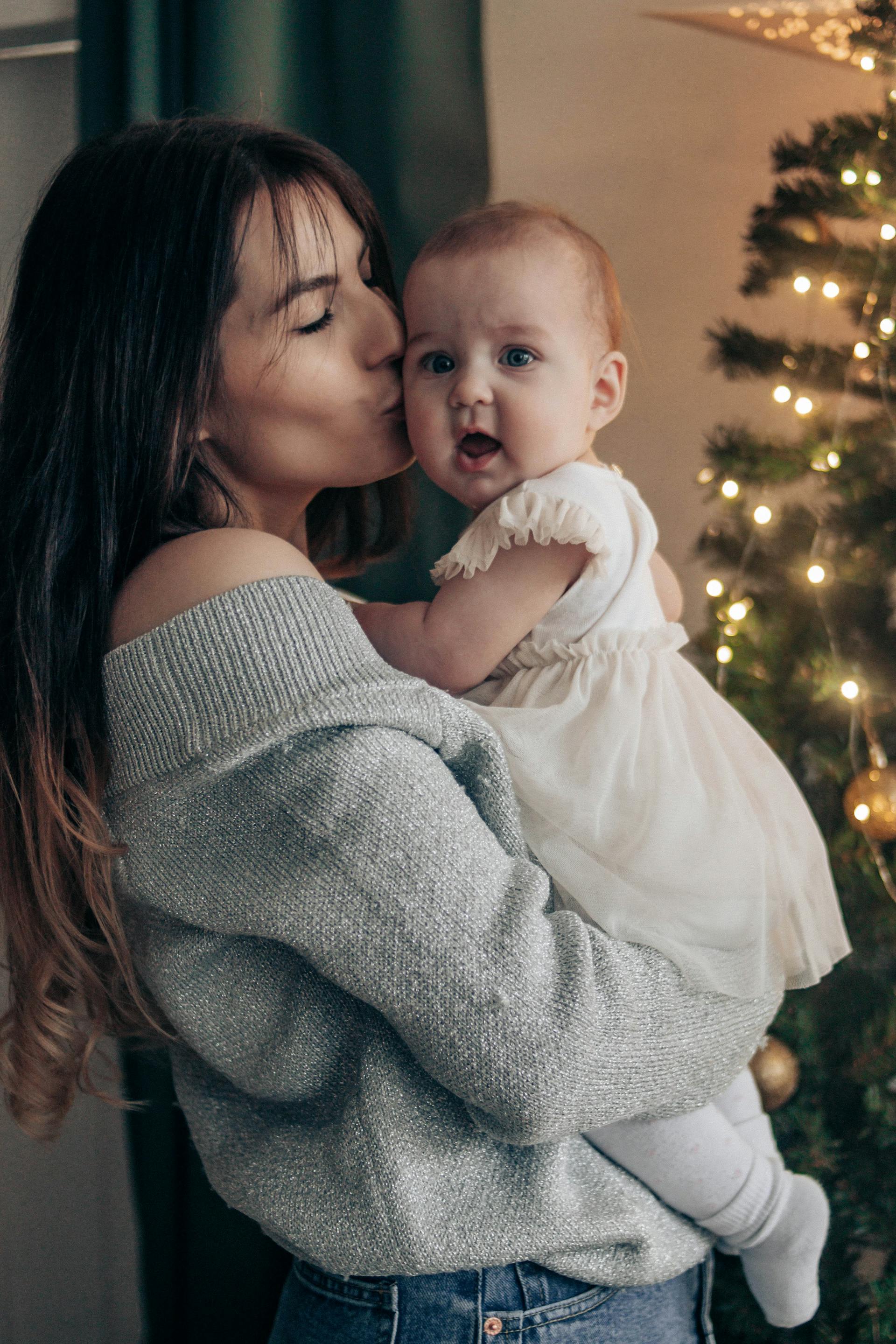 Eine Mutter küsst ihre kleine Tochter | Quelle: Pexels