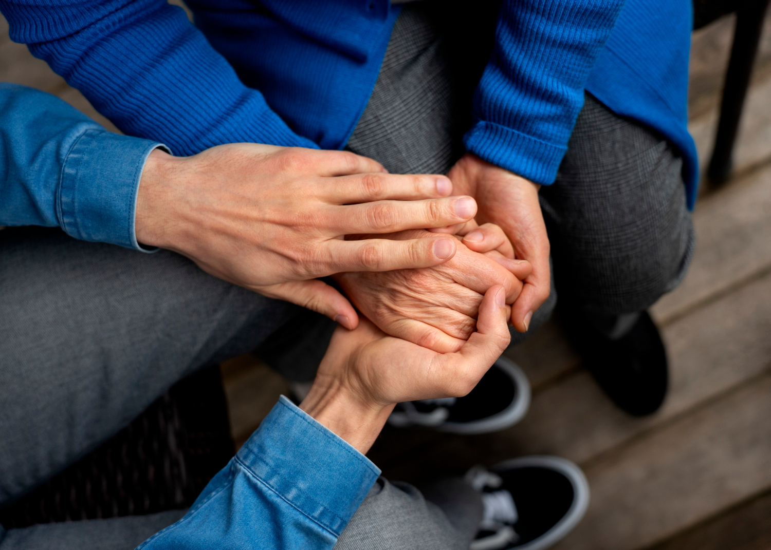 Zbliżenie mężczyzny trzymającego rękę starszej osoby | Źródło: Freepik