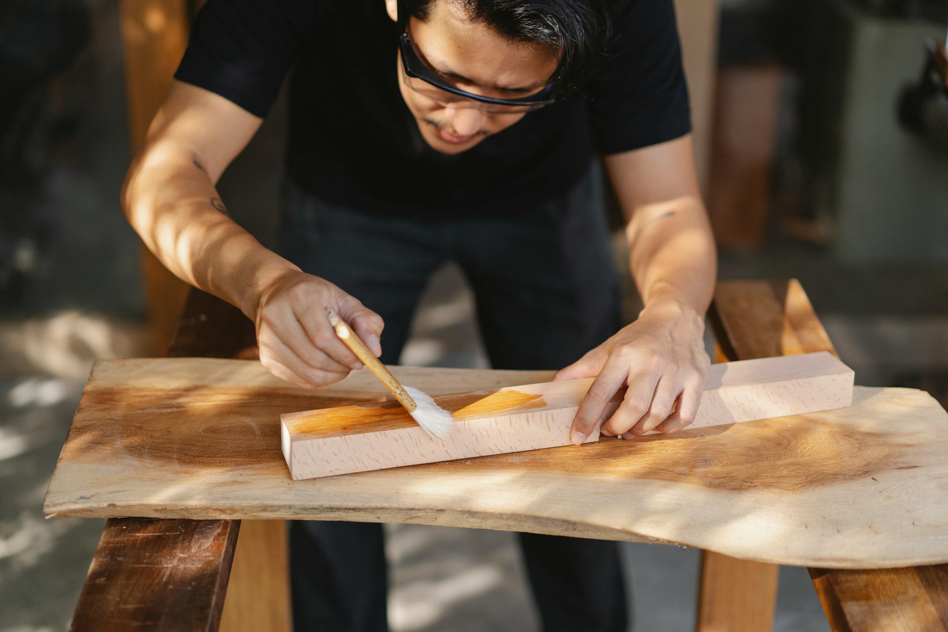 Ein Mann beim Lackieren von Holz | Quelle: Pexels