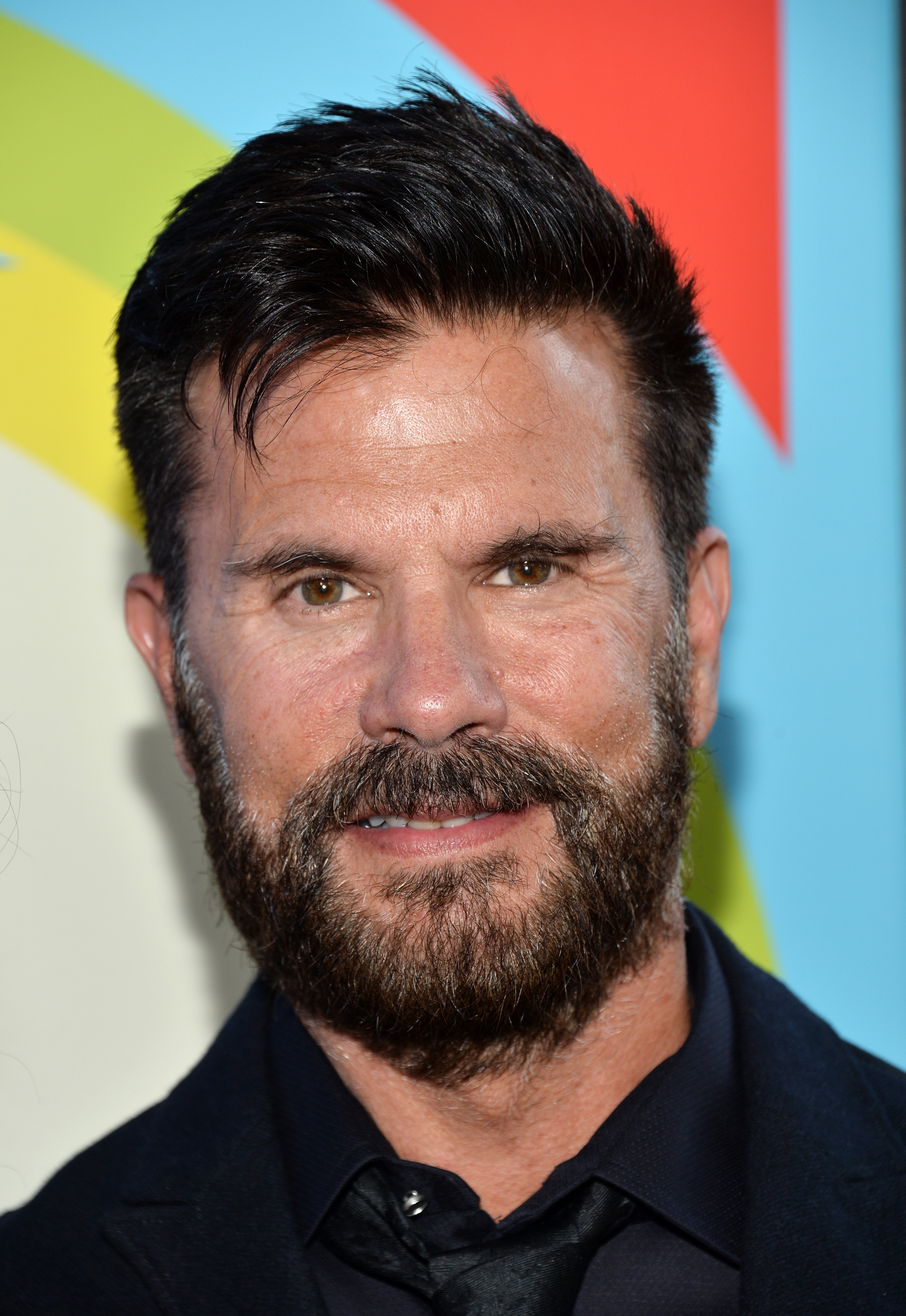 Lorenzo Lamas besucht am 2. Juni 2015 die Premiere von „Love & Mercy“ im Samuel Goldwyn Theater in Beverly Hills, Kalifornien. Der Schauspieler lächelt direkt in die Kamera und kombiniert einen vollen, graumelierten Bart sowie kurzgeschnittenes, strukturiertes dunkles Haar mit einem eleganten schwarzen Hemd, einer passenden Krawatte und einem maßgeschneiderten Sakko. | Quelle: Getty Images