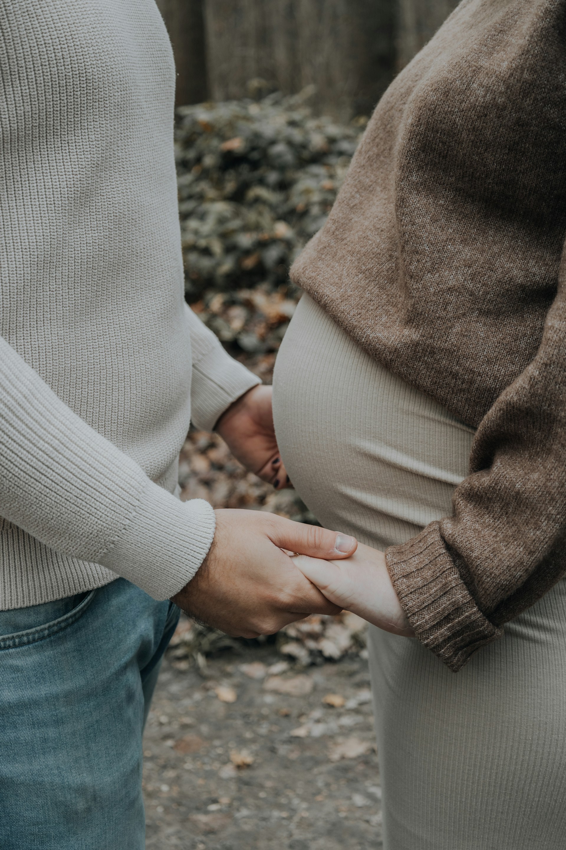 Ein Mann hält die Hände seiner schwangeren Partnerin | Quelle: Unsplash