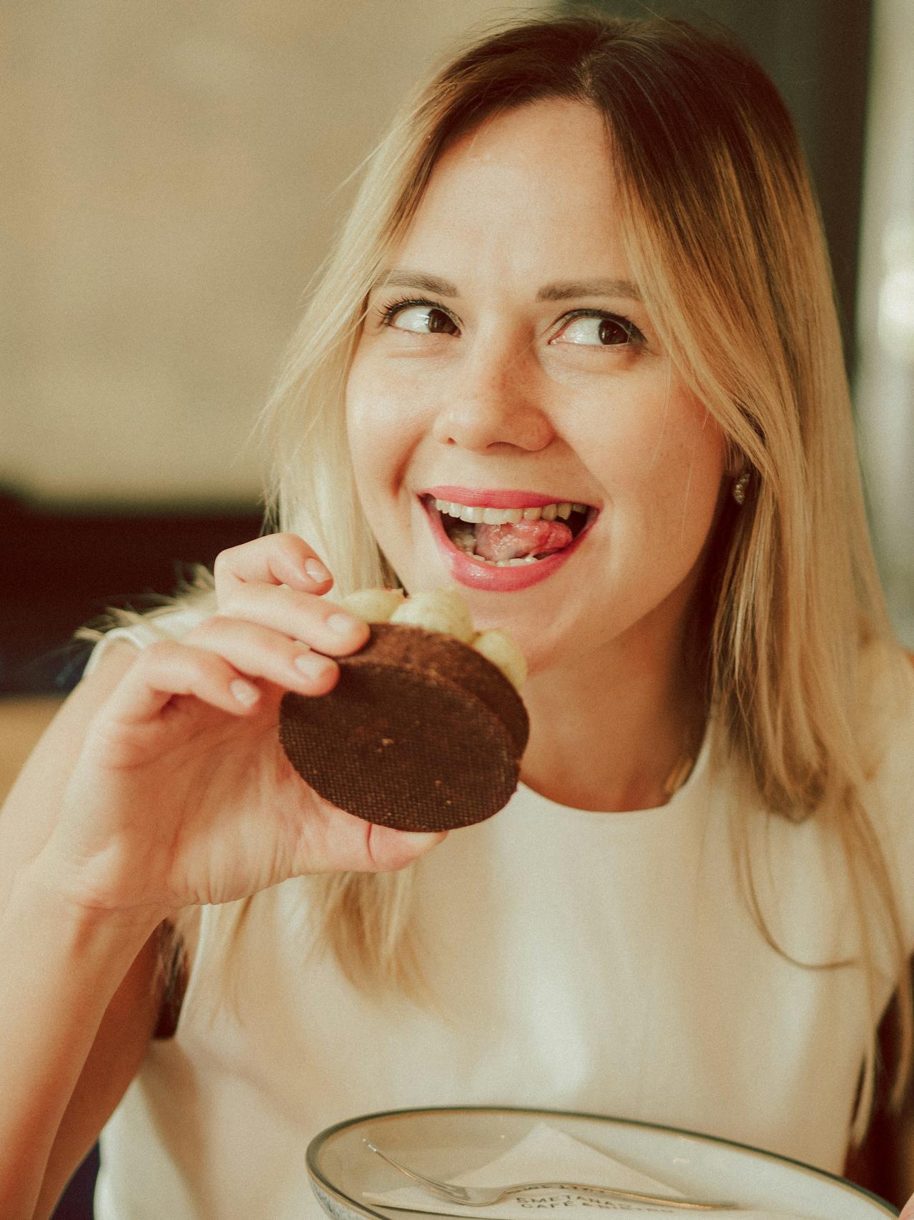 Eine glückliche Frau isst einen Cupcake | Quelle: Pexels